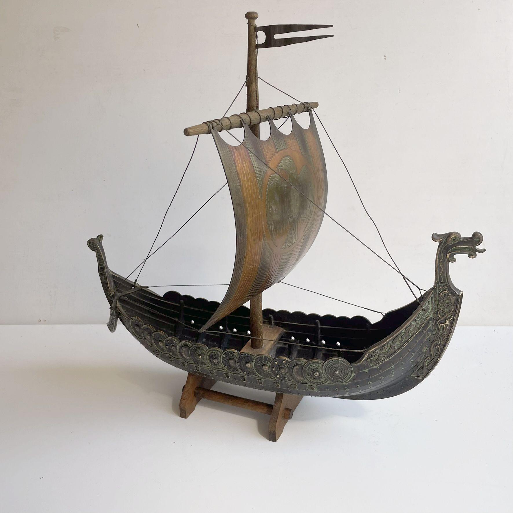 Beautifully craftmanship. Detailed model of Viking Ship in patinated bronze by Edward Aagaard for Copenhagen Iron Art. Intact and complete condition and with a small wooden stand for display on your desk or coffee table. 

Measurements: L: