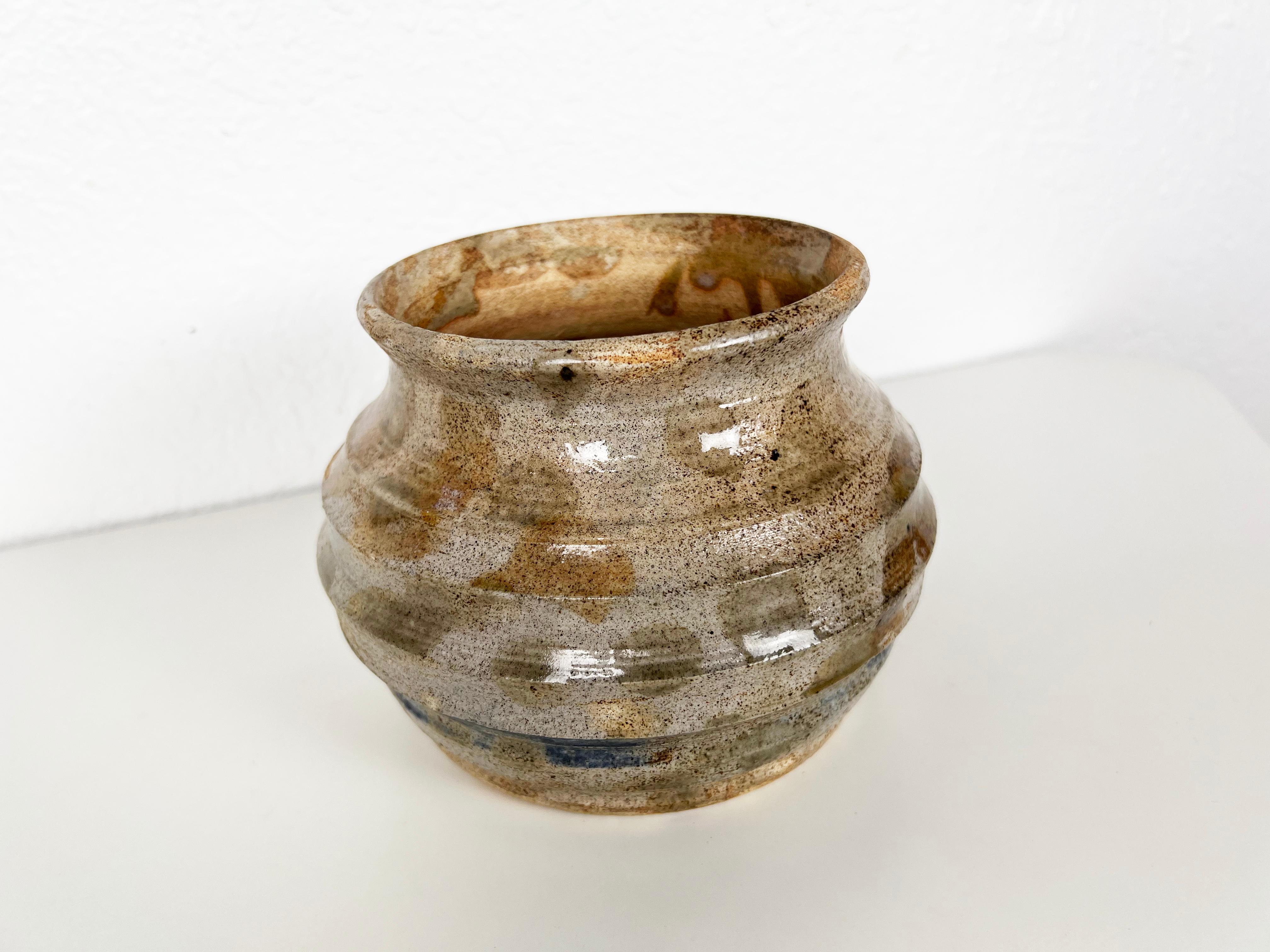 Vintage hand thrown ceramic planter with ridged sides and a glossy glaze in grey, blues and browns. Bottom is drilled for drainage. Signed.