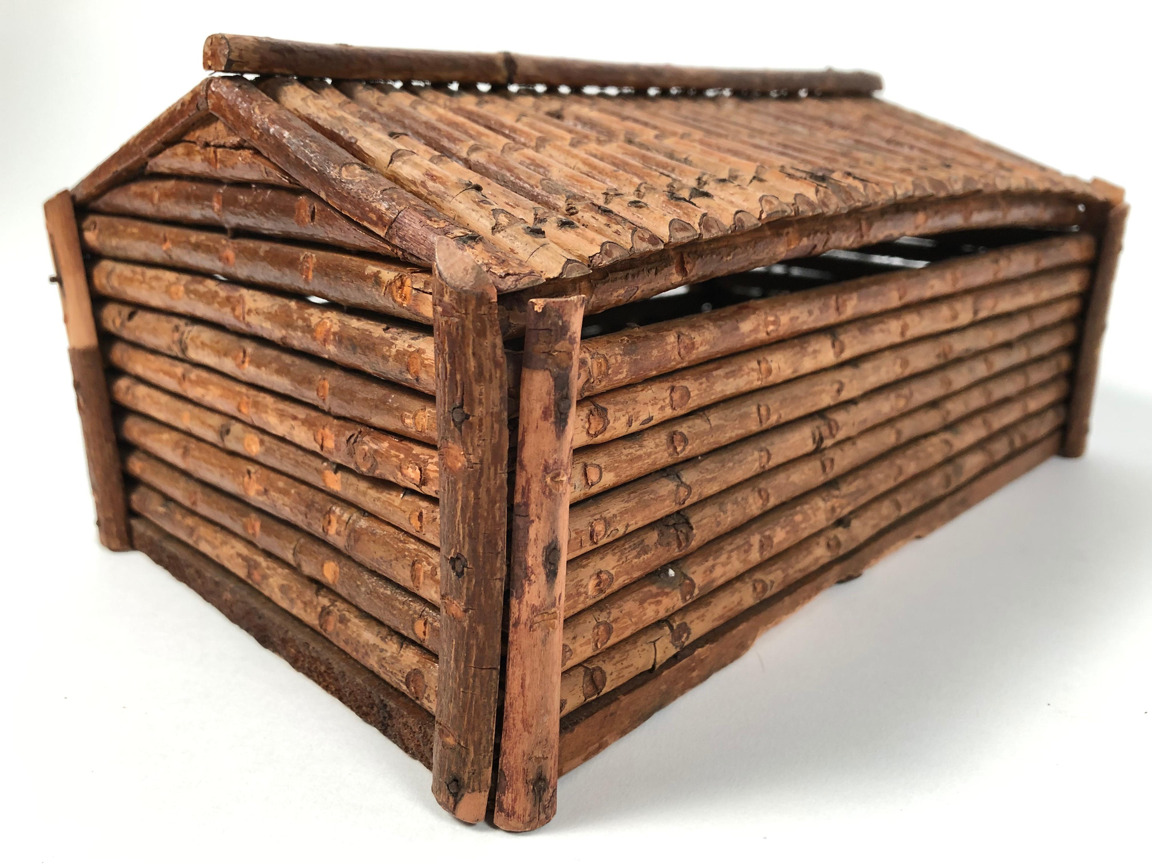 A vintage, handmade Folk Art twig log cabin covered box, the removable triangular roof over a rectangular base. Wonderfully elemental, this box reads as both country and modern with its simple, clean lines. We love it as a decorative object, but it