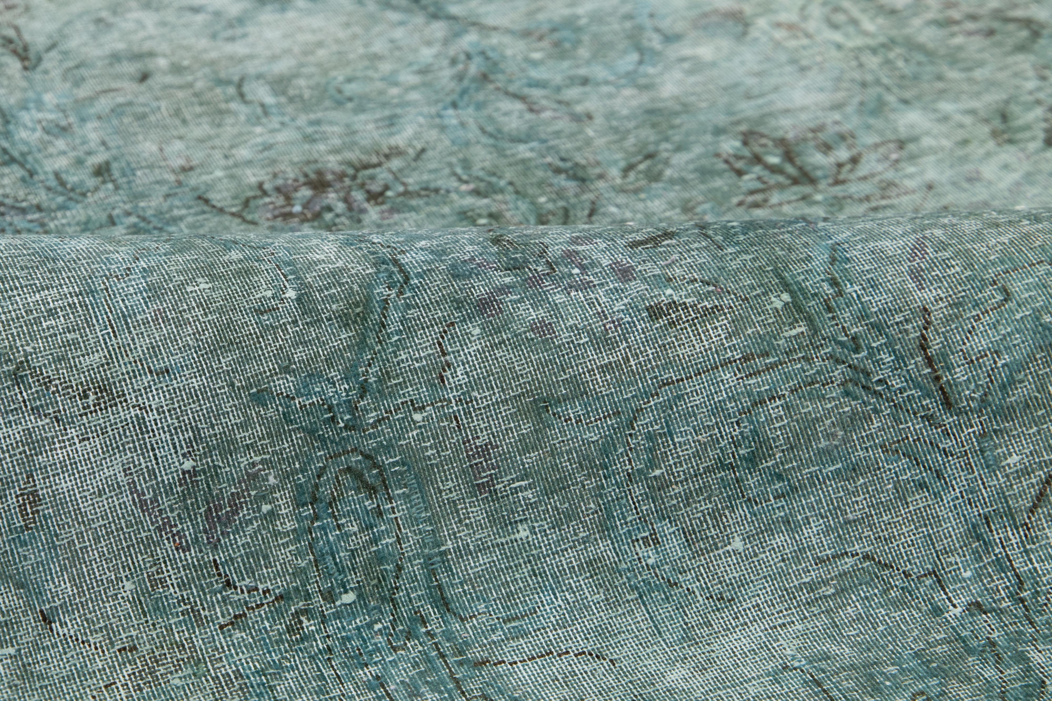 Ce tapis vintage en laine persane surteinte présente un champ de couleur vert captivant avec de charmants accents gris et bruns.

Ce tapis mesure 2'10