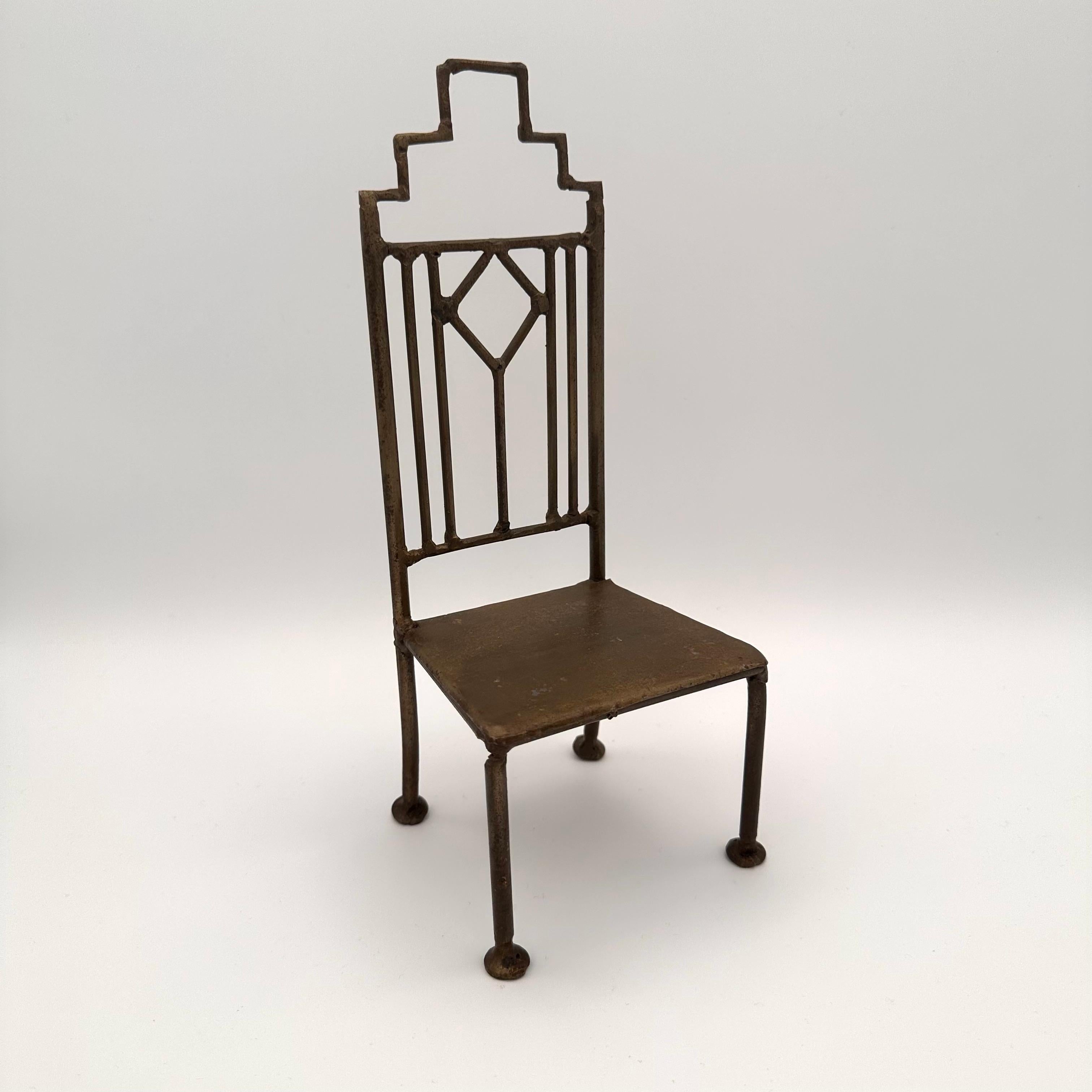 Einzigartiger handgefertigter Vintage-Miniatur-Metallstuhl. Art Deco inspiriert mit einem geometrischen, wolkenkratzerähnlichen Rauten- und Rechteckmuster auf der Rückseite. Die Sitzfläche ist flach und kann eine Kerze oder eine kleine Pflanze
