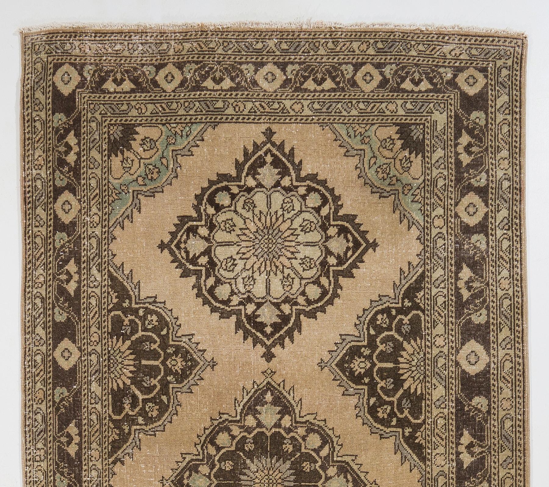 A vintage Turkish runner rug. It was hand-knotted in the 1960s with low wool on cotton foundation and features a multiple medallion design. It is in very good condition, professionally-washed, sturdy and suitable for areas with high foot traffic.