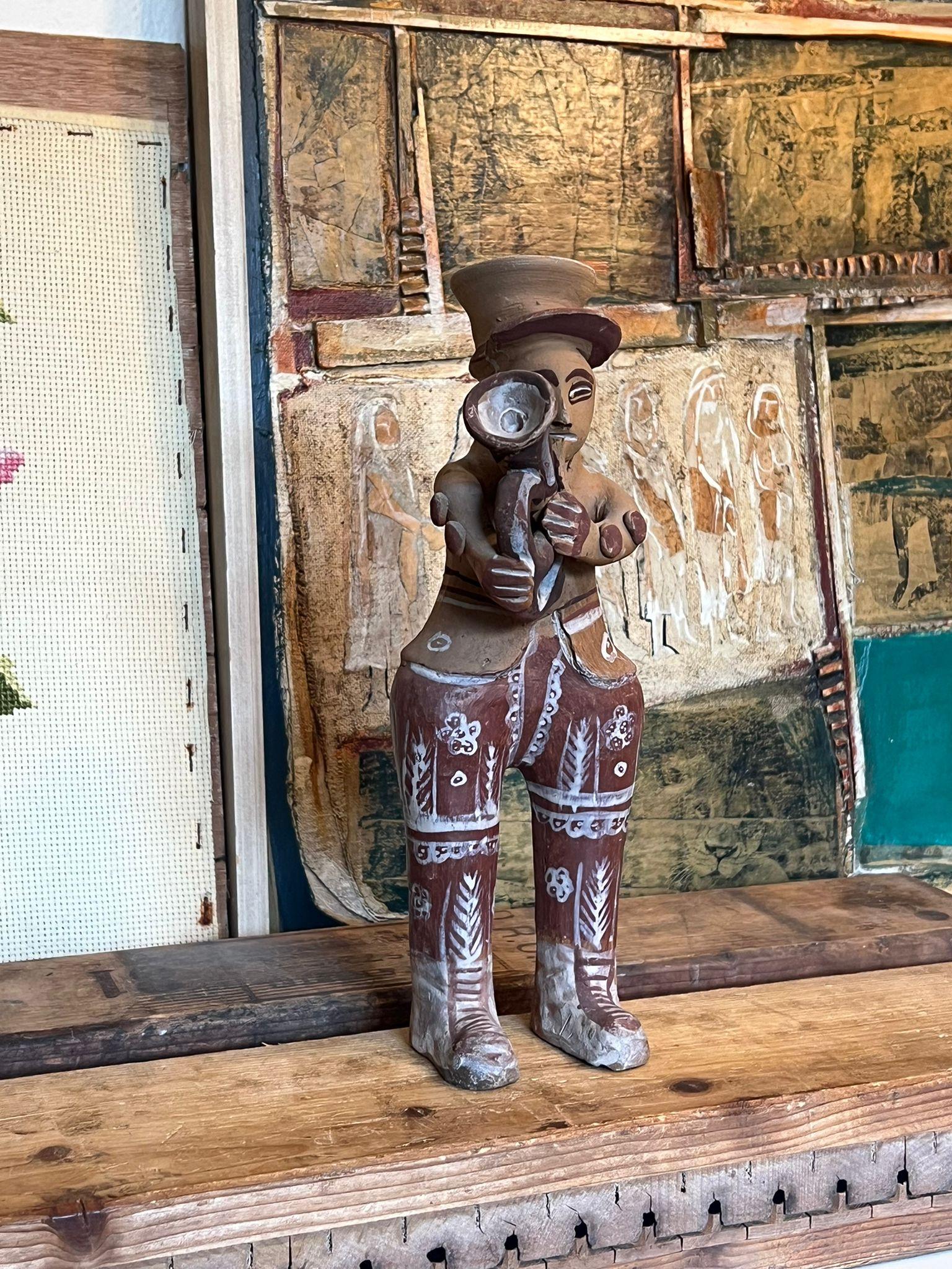 Questo portacandele unico nel suo genere è ritenuto arte popolare peruviana, ma non è stato confermato. Il musicista è dotato di uno strumento a corno e di un portacandele nel cappello. Questo pezzo ha una bella patina e carattere. Vintage Condit