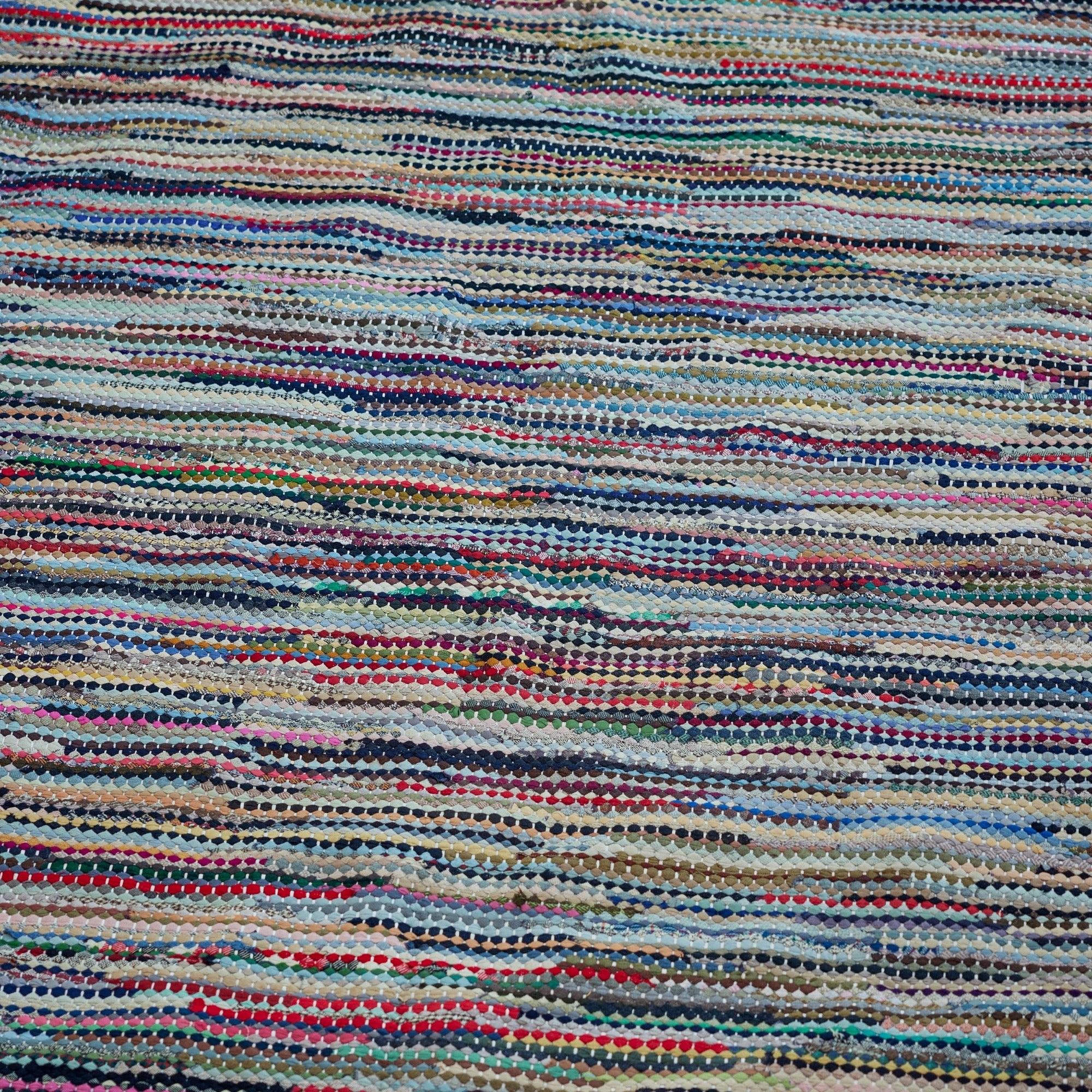 Un tappeto di pezza vintage fatto a mano e multicolore