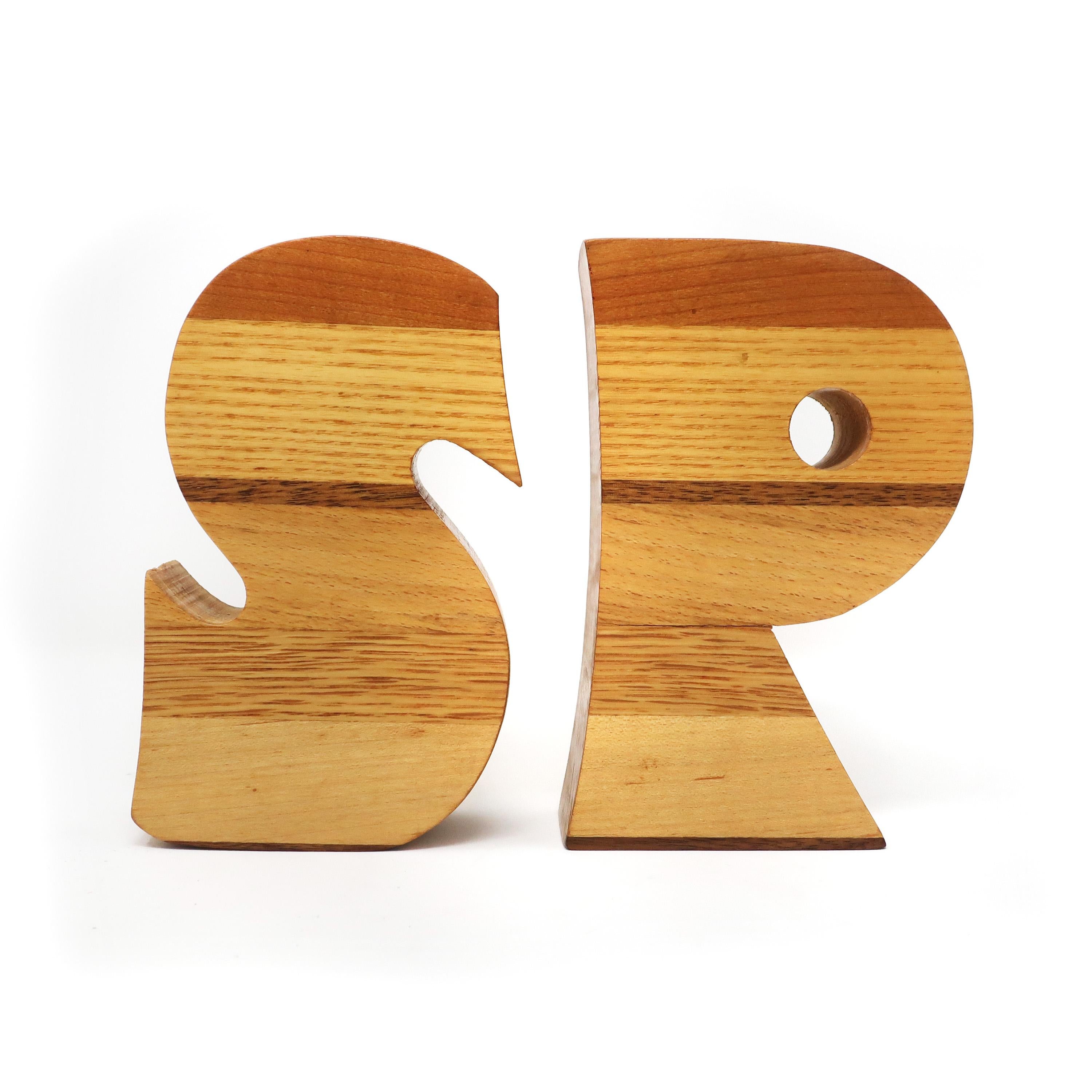 A set of vintage Mid-Century Modern wood salt and pepper shakers in the shape of an “S” and a “P”. Almost six inches tall and made of brightly figured wood with contrasting darker stripes. These scream 1970s! Very well constructed with new cork
