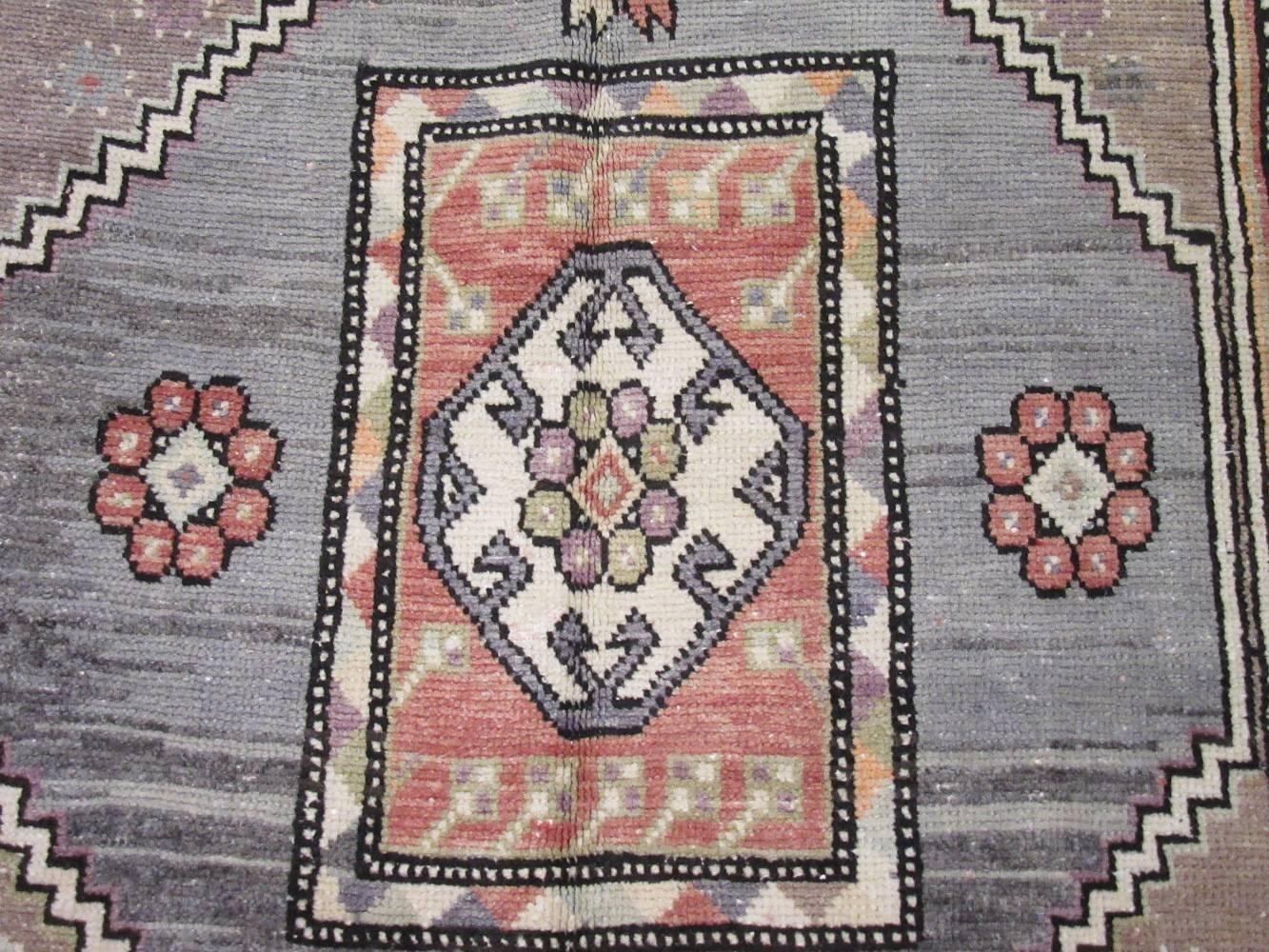 This is a vintage hand-knotted rug from the Anatolian region in Turkey. The rug has a simple nomadic design with primary colors. It is made with wool colored with natural dyes. The rug measures 5' 1'' x 8' 7'' and in great condition.