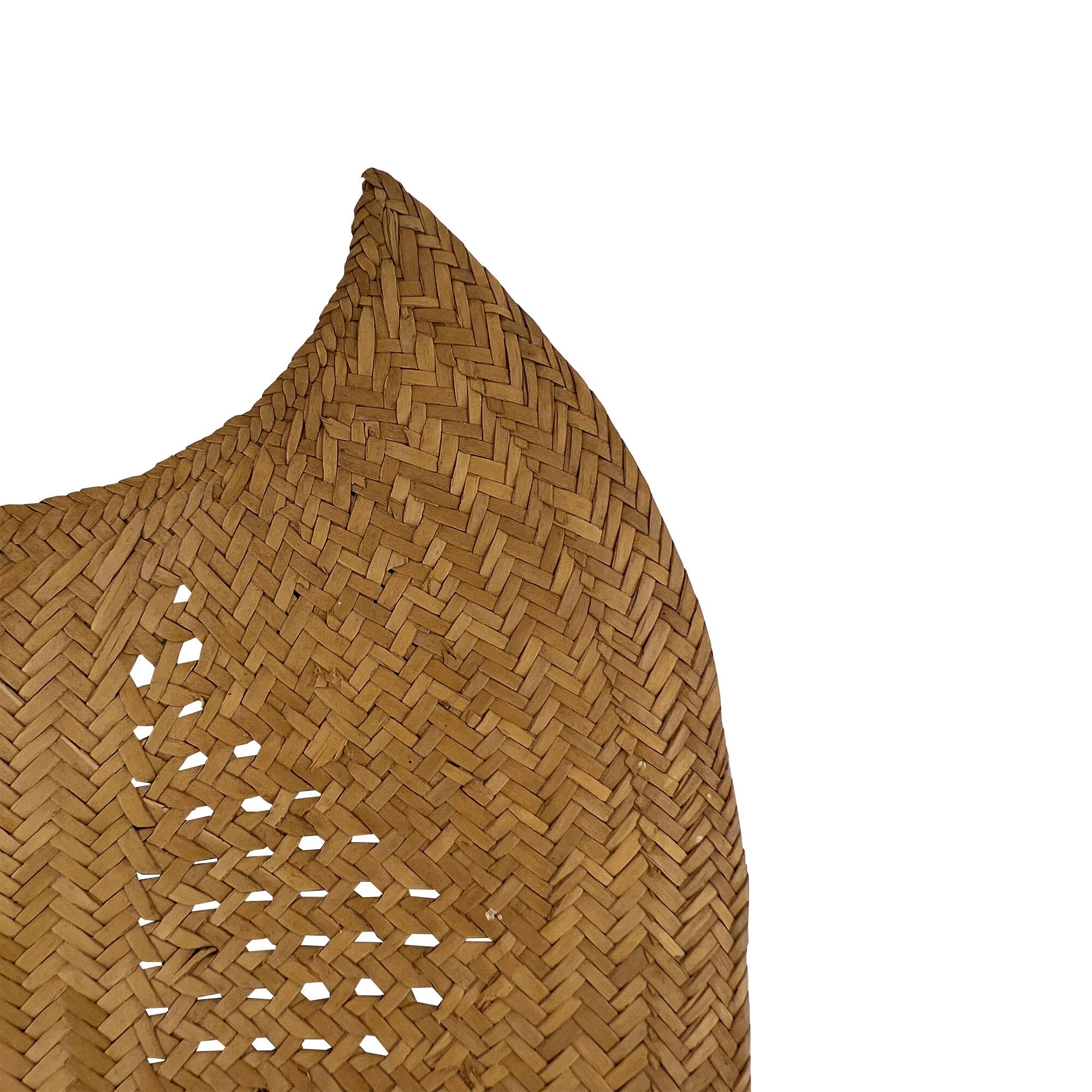 Zelebrieren Sie die alte Handwerkskunst mit diesem auffälligen, handgeflochtenen Bambusfächer im Vintage-Stil, der sich durch einen zart durchbrochenen Körper, eine skulpturale blattähnliche Silhouette und einen handbemalten Holzgriff auszeichnet.