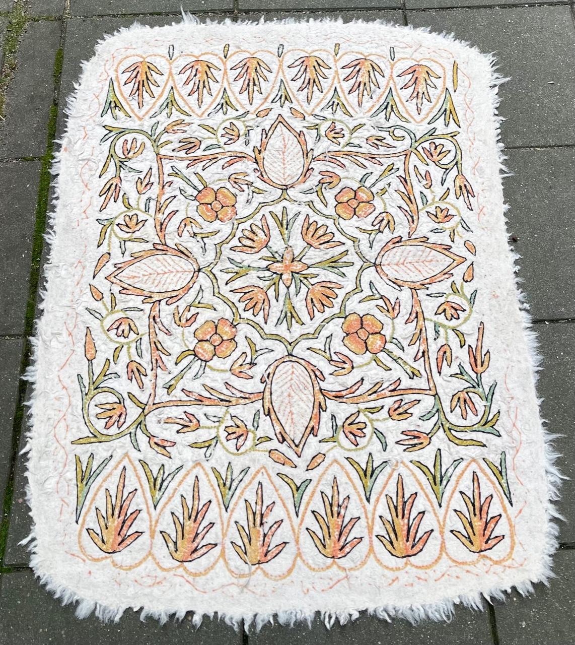 A vintage ivory small-pile rug or runner in Morrocan berber wool. The subject matter are flowers and leaves and everything is done by hand. The colors are neutral and subtle and the design is organic and underplayed. It has an almost primitive or