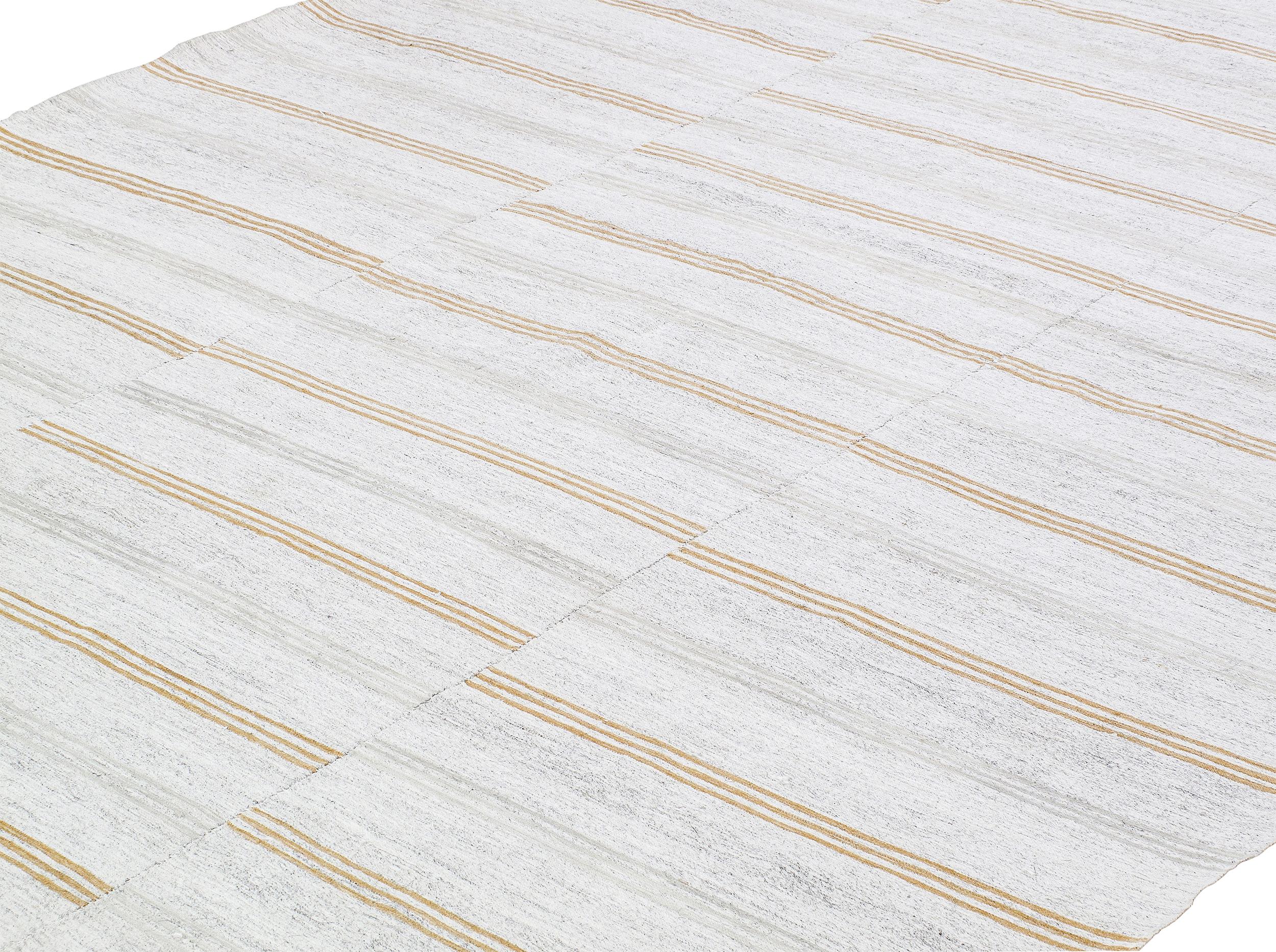 This 50-year-old vintage Turkish kilim features a unique striped design with orange lines running horizontally across three distinct panels. Its minimalistic yet bold pattern is perfect for enhancing modern, bohemian, or eclectic spaces. Ideal for