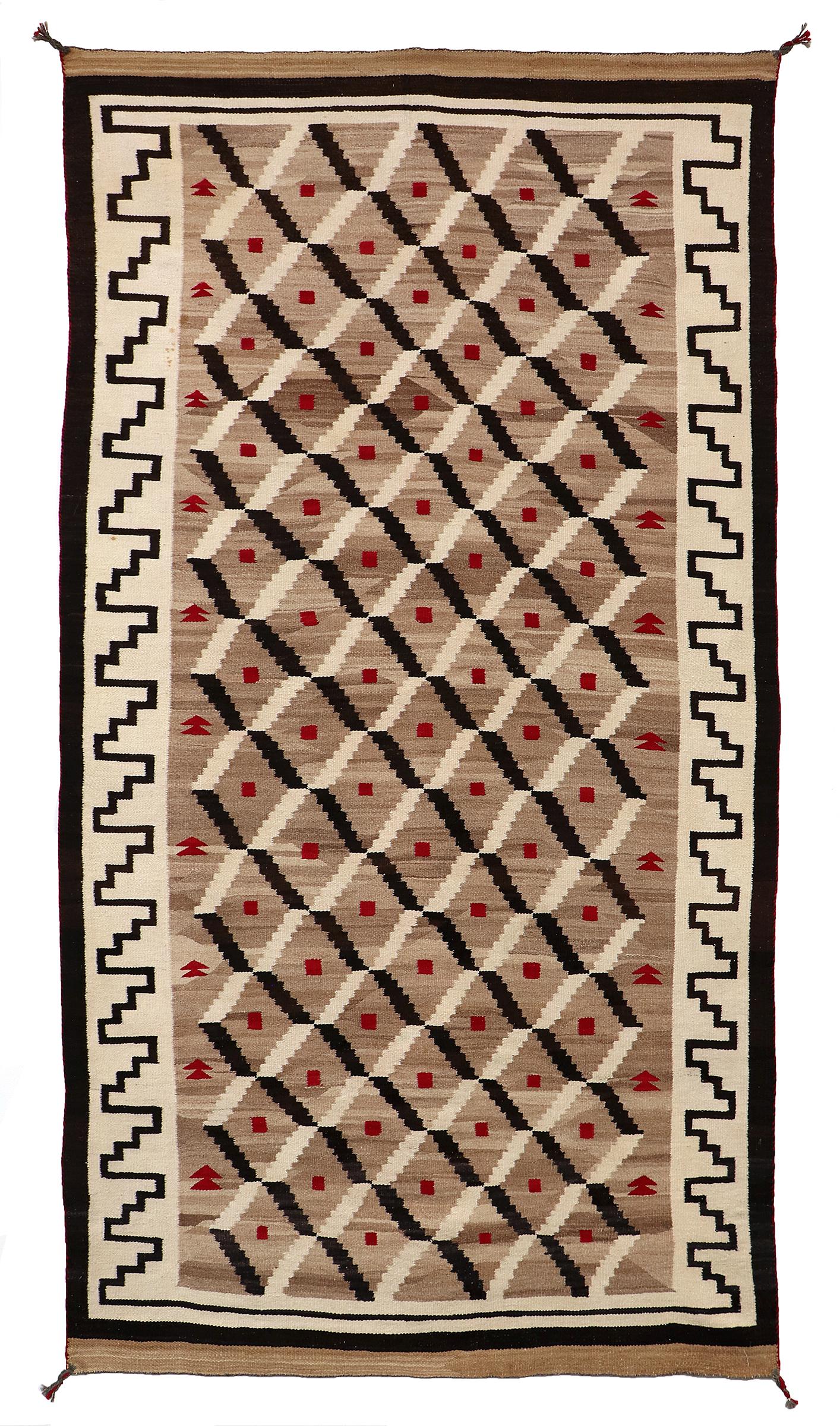 Questa straordinaria tessitura Navajo (Diné) d'epoca risalente al XX secolo è un superbo esempio di artigianato tessile e di arte culturale indigena americana. Sapientemente tessuto a mano con lana filata a mano e tinto con vivaci pigmenti
