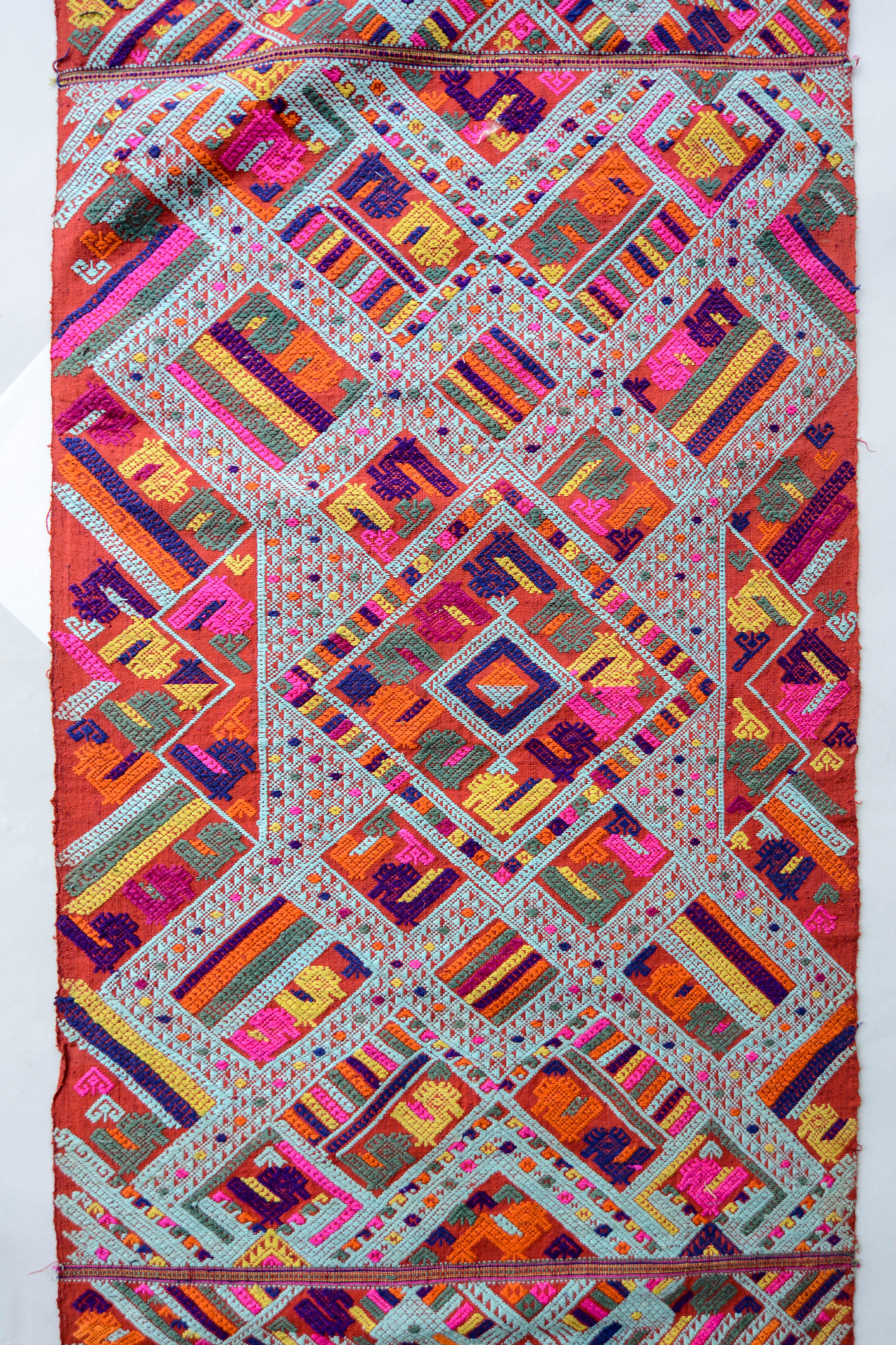 Vintage handwoven silk shawl end panel Tai Nue from Laos mid-20th century. Supplementary weft technique, with geometric designs and depicting mythological animals (nak river dragons) with protective qualities.
This intricately woven end piece is