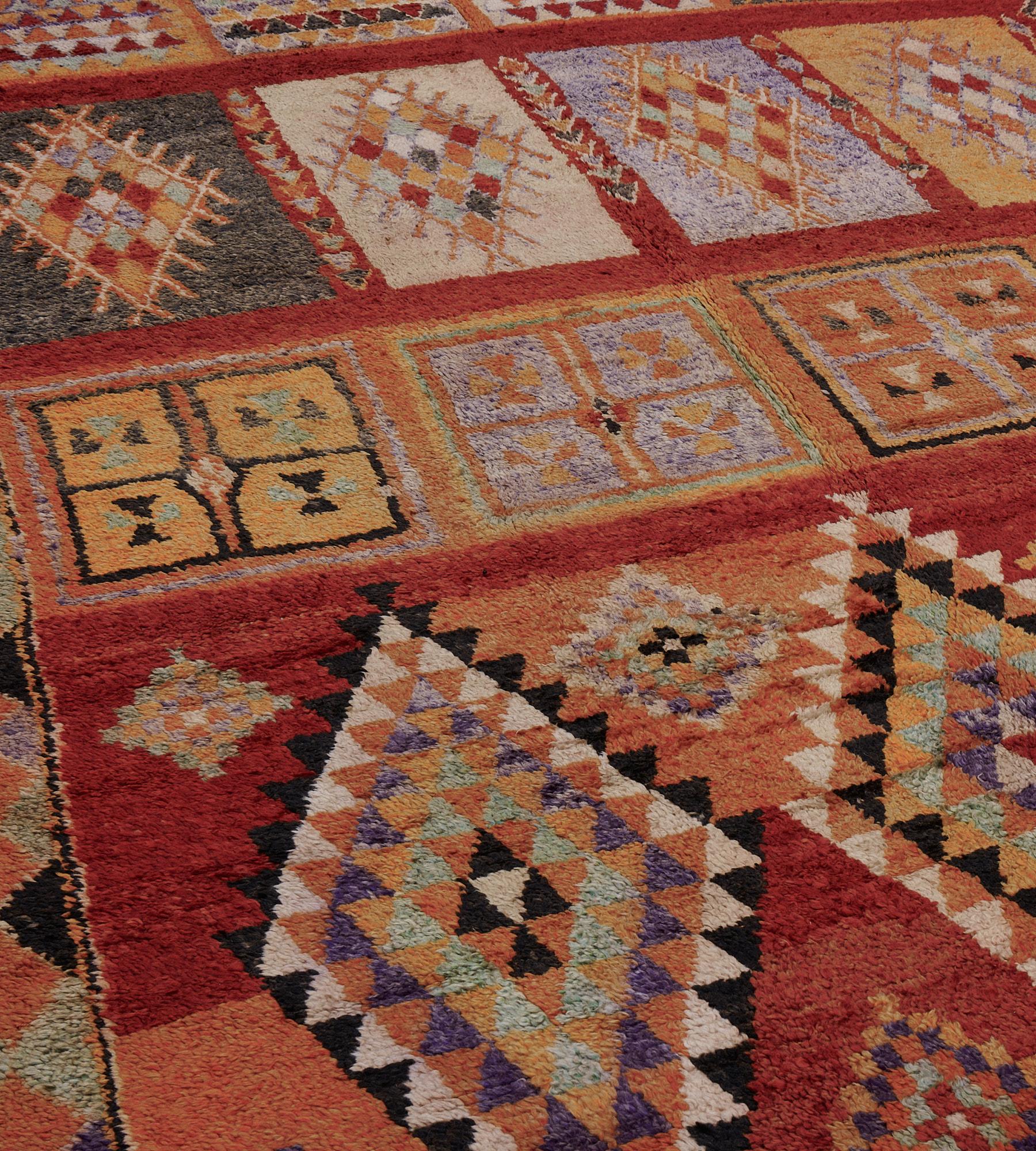 This hand woven wool vintage Moroccan rug features bold geometric patterns and lively colors.