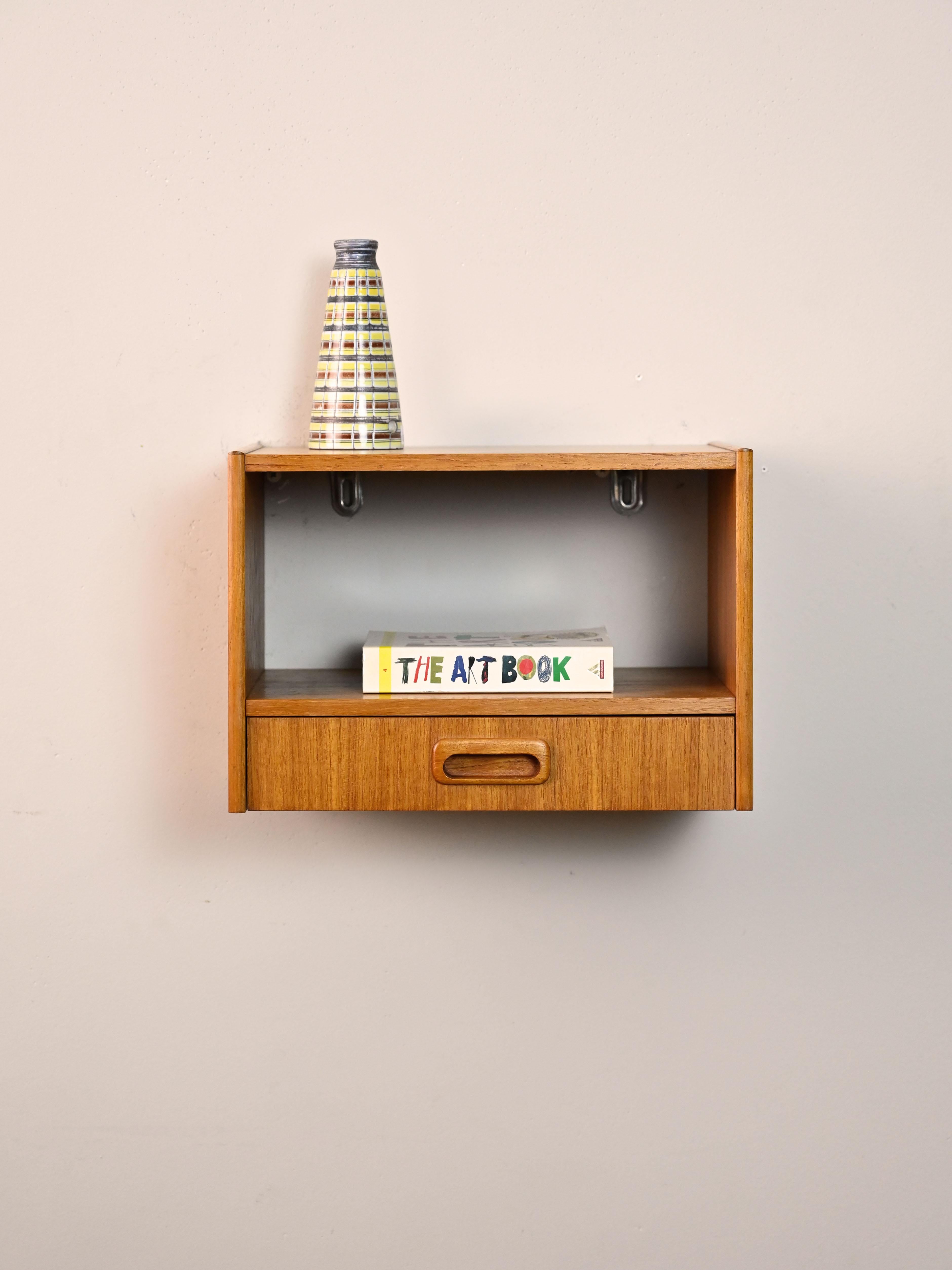 Scandinavian teak nightstand with drawer.

An original 1960s cabinet perfect for a small room.
The carved wooden drawer handle is synonymous with quality and the period of manufacture.
Thanks to the double shelf, it can also be hung in the entryway