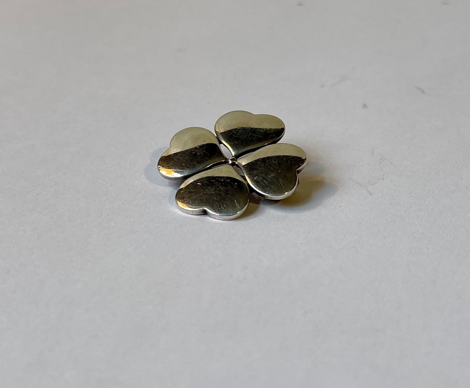 A stylish four clover pin brooch cleverly made from 4 connected hearts. Designed and made by Hans Hansen in Denmark ca 1960-70. Hallmarked: HH, 108, Denmark, 925s. Measurements: 27x27 mm. Weight approx. 10 grams.