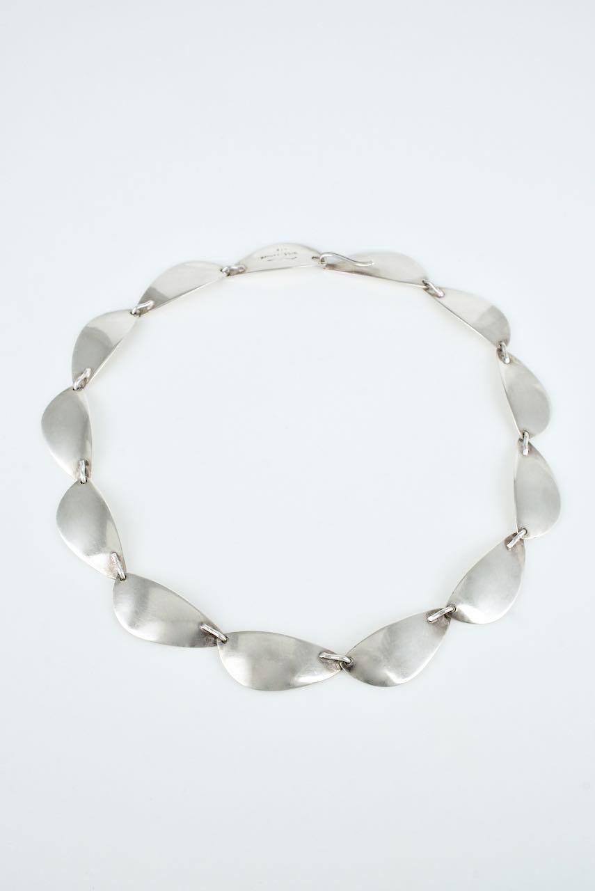 A vintage solid silver Modernist leaf link necklace by one of the most famous Danish designers Hans Hansen, consisting of  13 panels of a stylised concave leaf motif with a concealed hook closure - a lovely contemporary necklace that is as modern as
