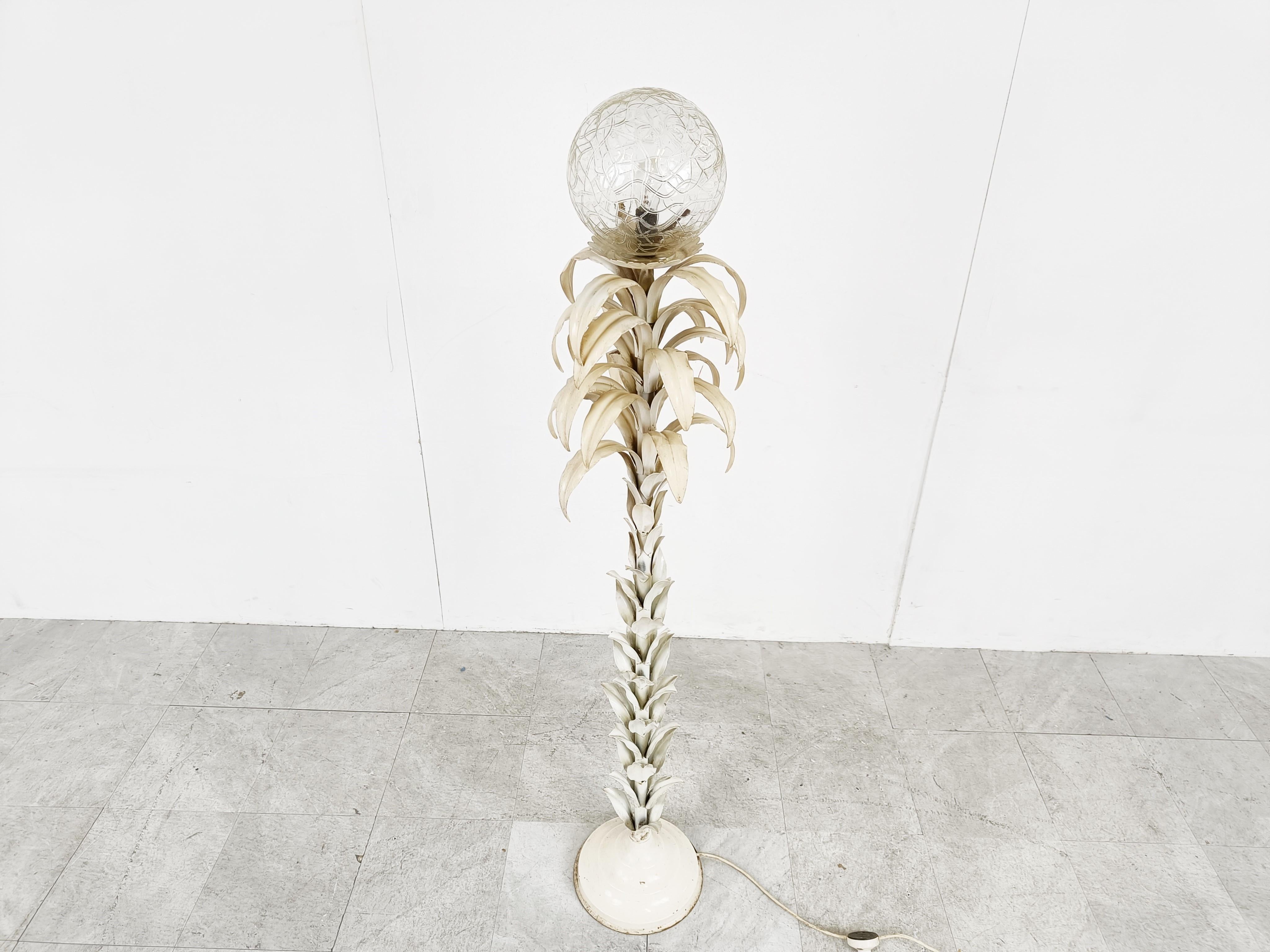Mid century floral floor lamp with a beautiful amber coloured hand made glass globe.

White lacquered metal leafs.

The floor lamp emits an amazing light.

Original condition with some paint loss adding to the charm.

Comes with a foot