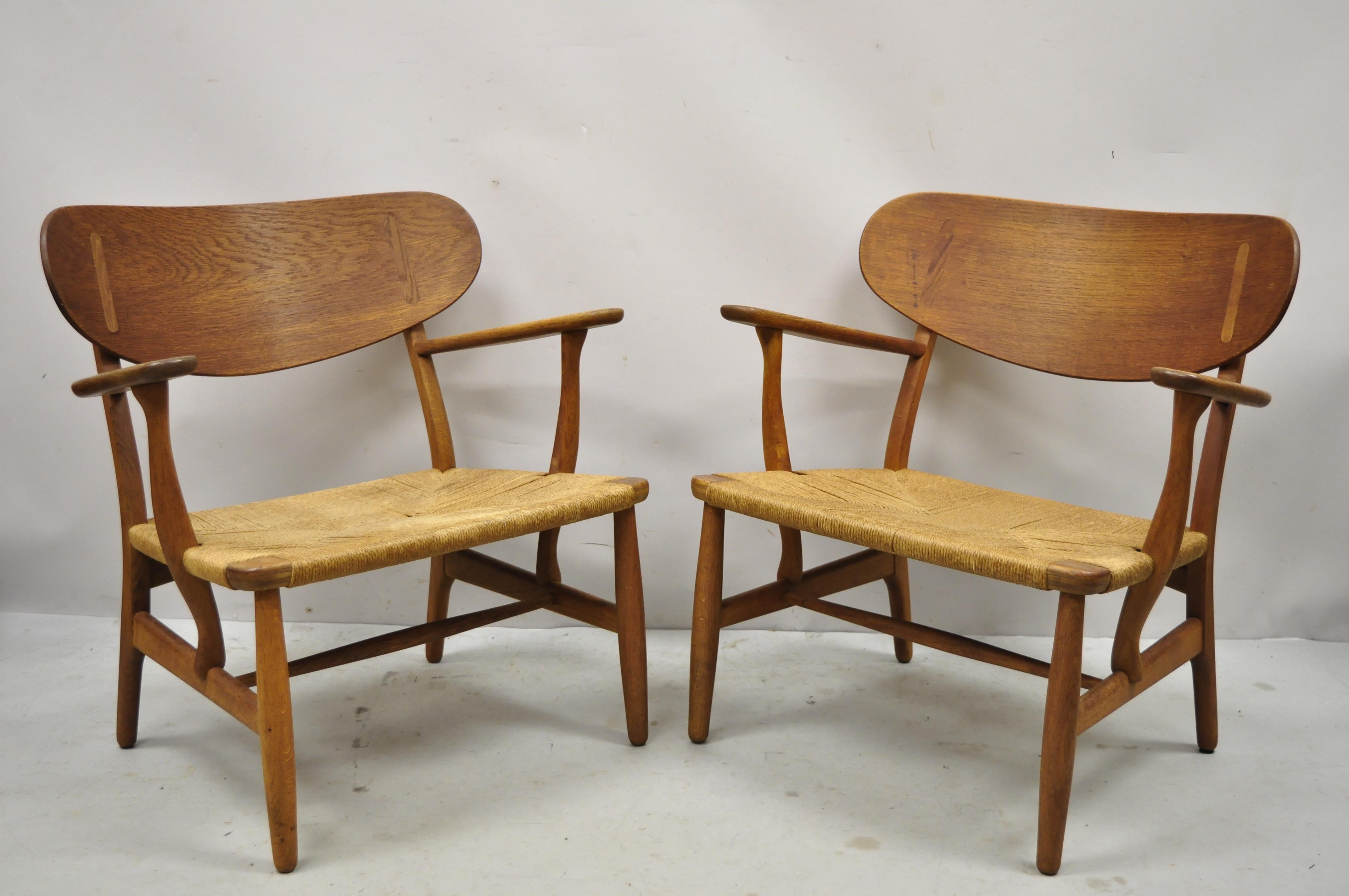 Vintage Hans Wegner CH22 Carl Hansen & Son Oak lounge easy chairs - a Pair. Item features woven paper cord seats, solid oakwood frames, original Hans Wegner stems to underside, quality Danish craftsmanship. Measurements: 28.5