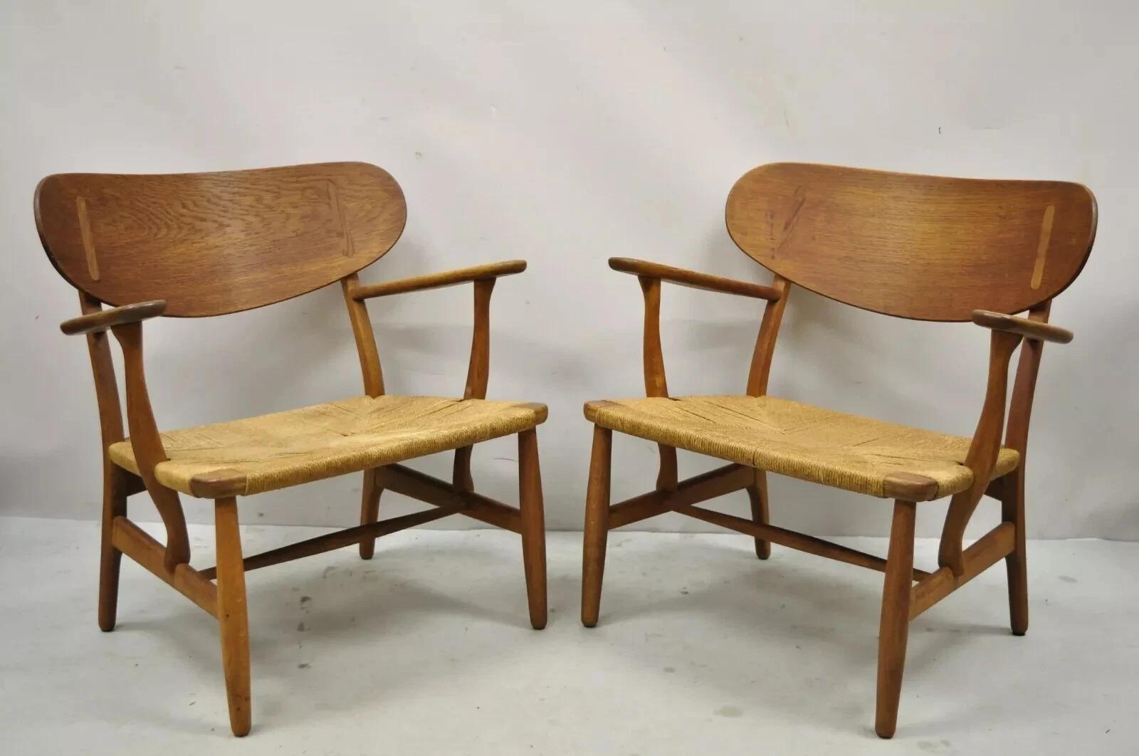 Original Vintage Hans Wegner CH22 Carl Hansen & Son Sillones de diseño moderno de mediados de siglo en roble - un par. Asientos de cuerda de papel tejida, armazón de madera maciza de roble, sellos originales de Hans Wegner en la parte inferior,