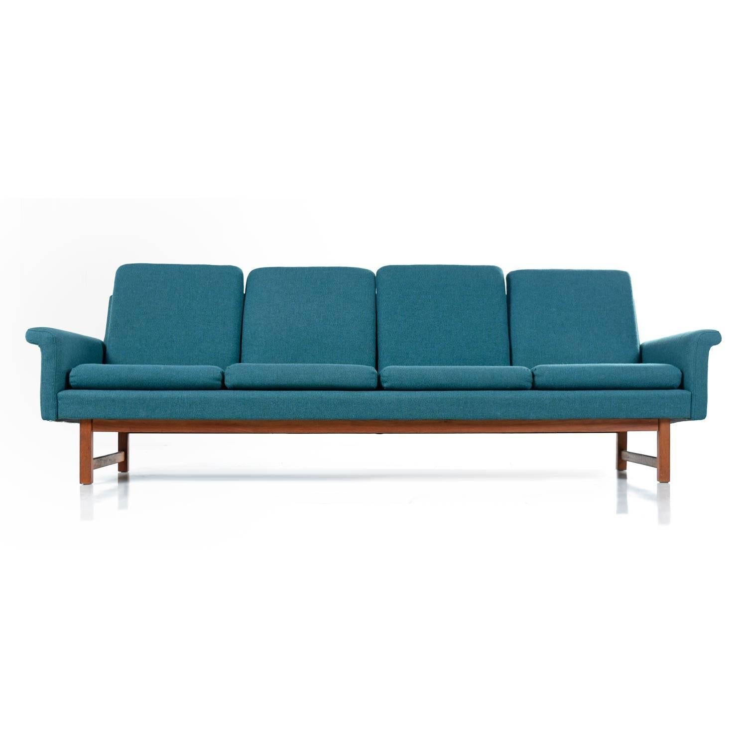 This sleek midcentury four-seat sofa, in the style of Folke Ohlsson celebrates beautiful Danish design. Exceptional, all original condition. The blue fabric is as stylish and fashionable now as it was in the 1960s. Segmented, separate back and head