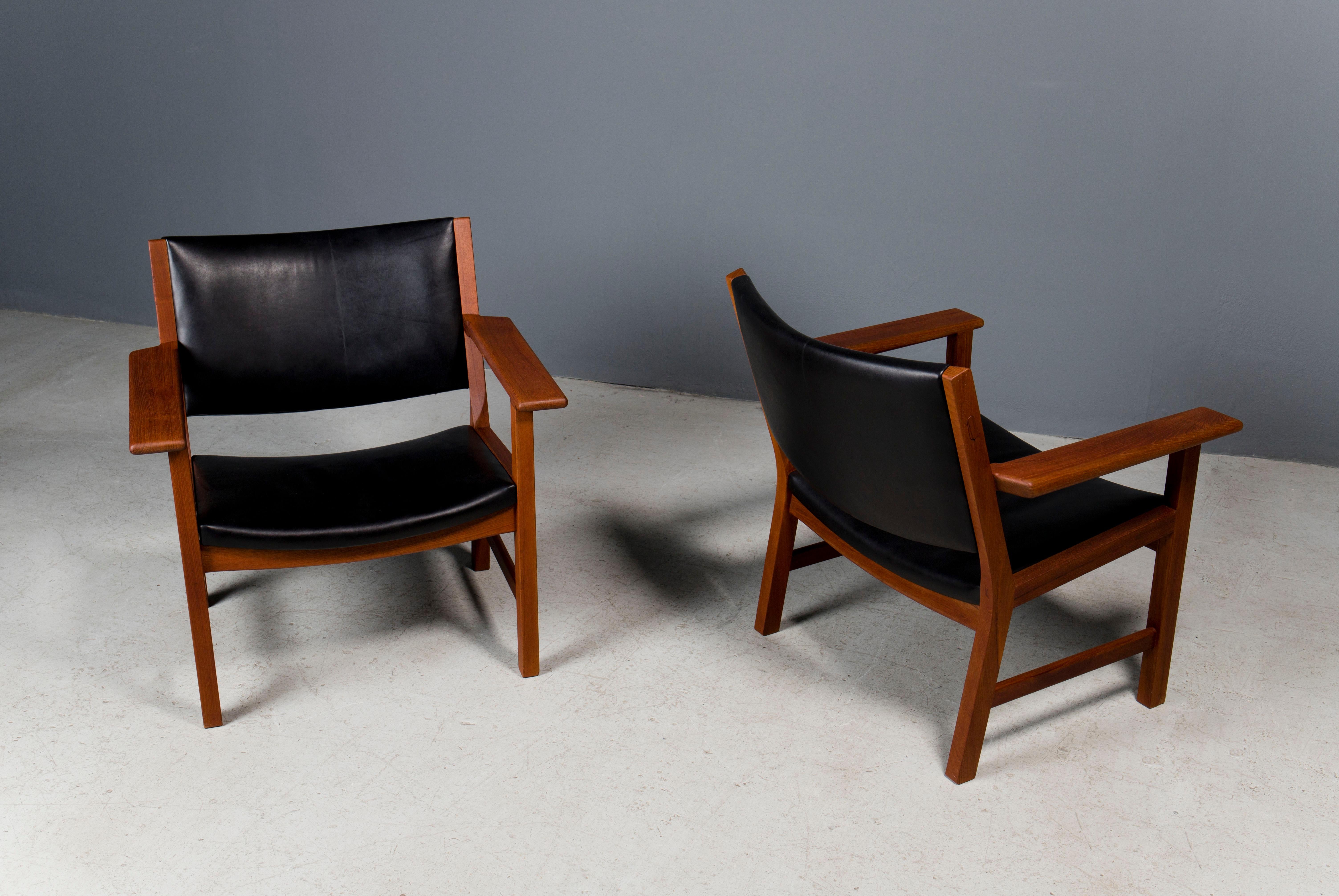 Rare pair of lounge chairs by Hans Wegner. They are in excellent vintage condition and upholstered in black leather.