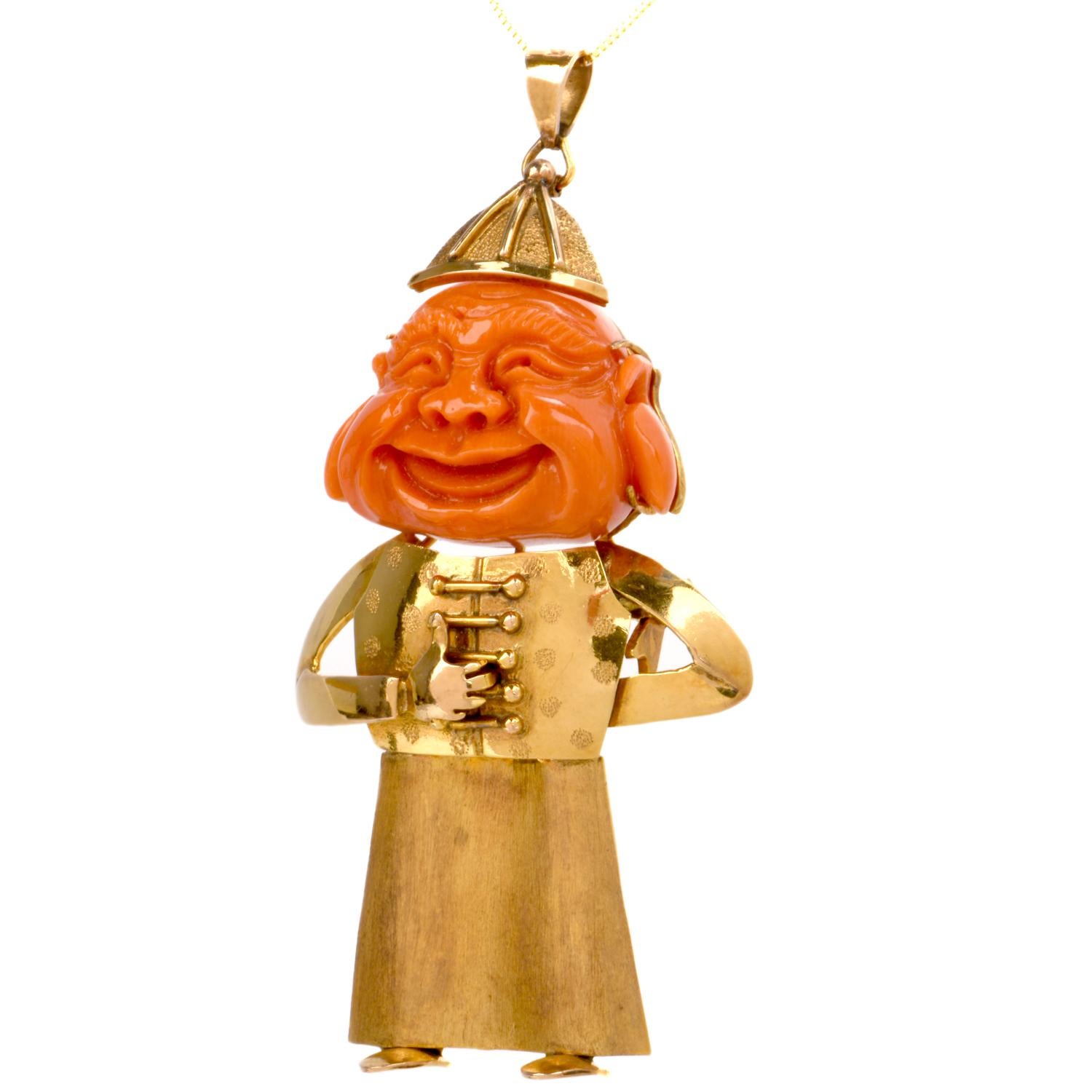 This whimsical coral smiling Happy Buddha pendant is crafted in solid 18-karat yellow gold. Showcasing an expertly carved salmon colored coral Buddha face prong-set in gold. Adorned by a royal jesters body dressed in a skirt, button detailed shirt,