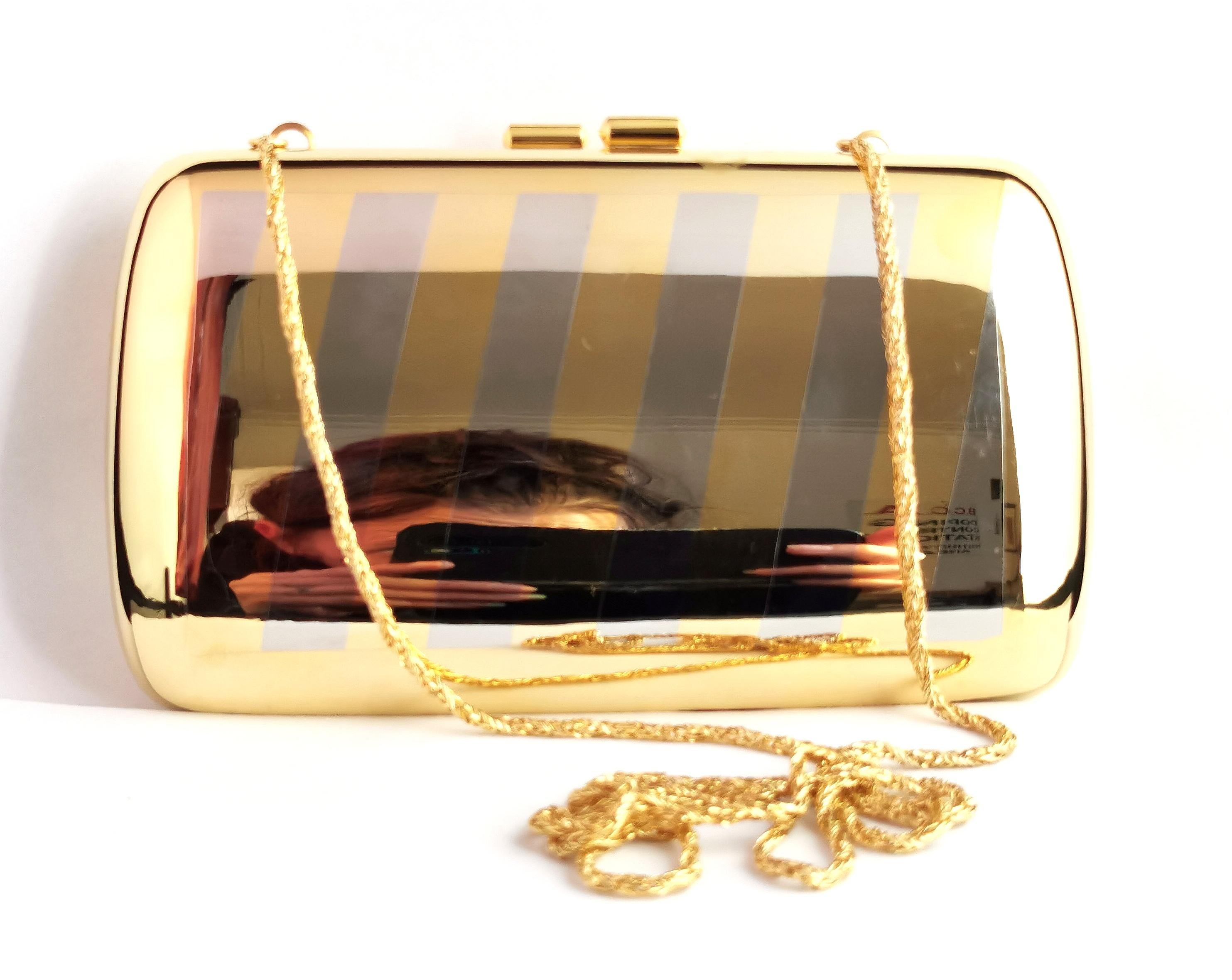 A gorgeous vintage Pierre Cardin hard case metal evening purse or handbag.

It is a rounded rectangular shape with diagonal striping of gold and silver tone metal with a long gold tone metal handle.

Inside is lined with a beige velveteen and the