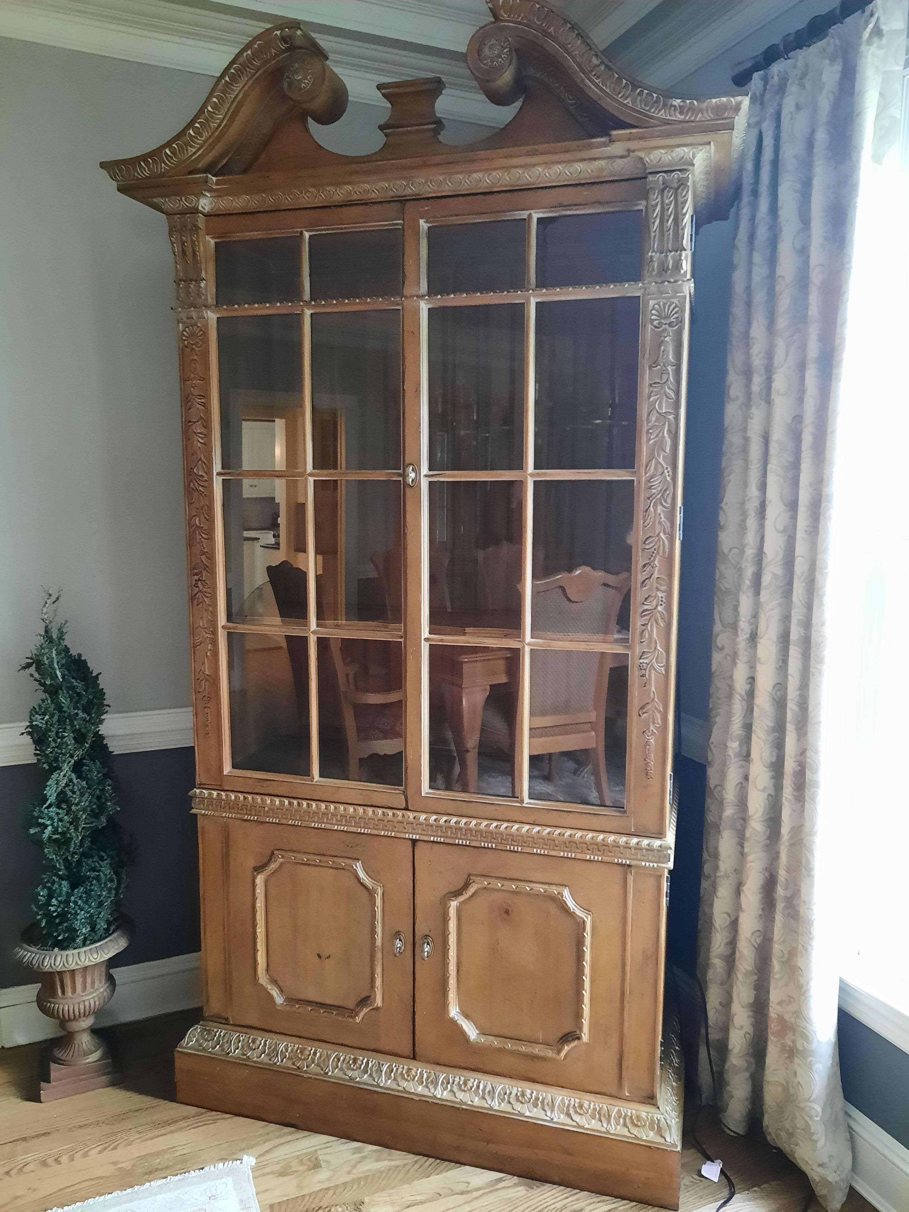 Vintage solid hardwood Hutch with 4 doors white washed to accent the carved details. Top has two doors with glass and two adjustable shelves with scalloped fronts. The bottom has one adjustable shelf and a drawer. There is strip lighting on both