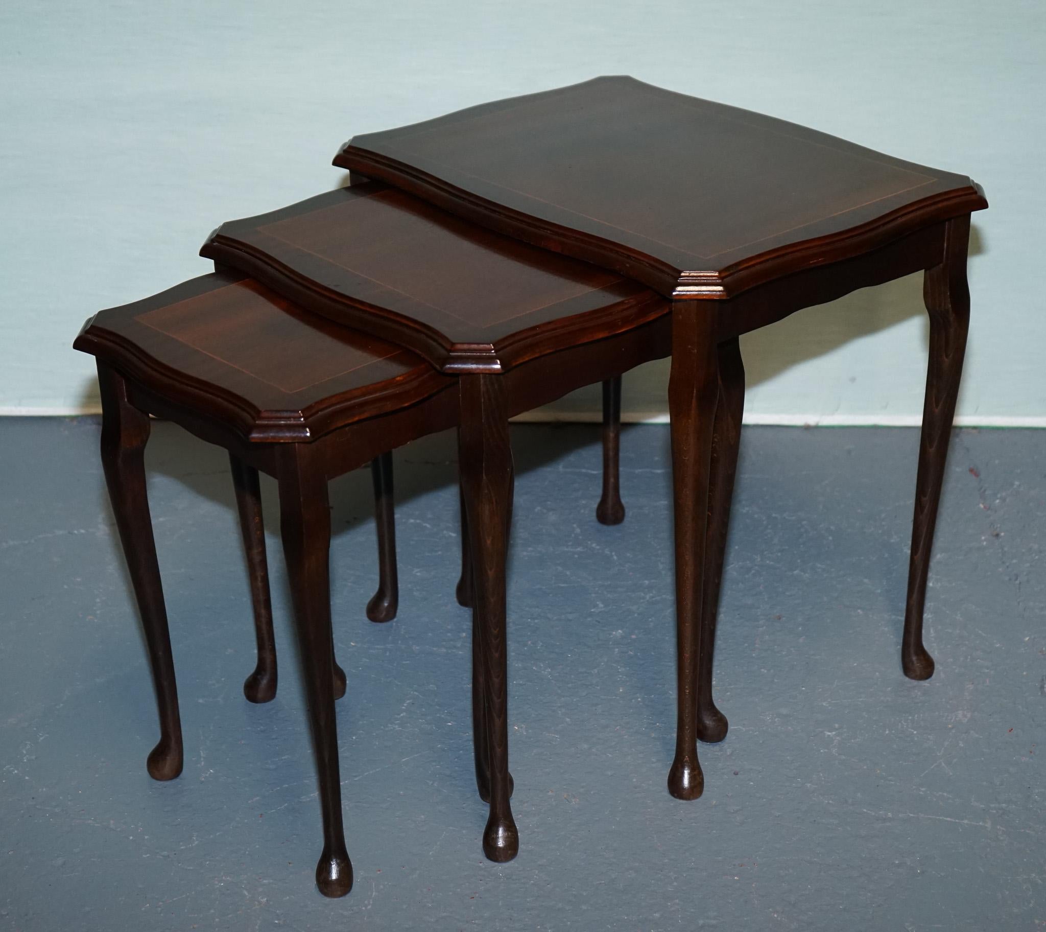 
Antiquités de Londres



Elegant ensemble vintage de trois tables gigognes en acajou fabriquées dans le style raffiné de la Reine Anne. Avec leurs bords serpentins magnifiquement façonnés et leurs bordures délicatement incrustées de cordes, ces