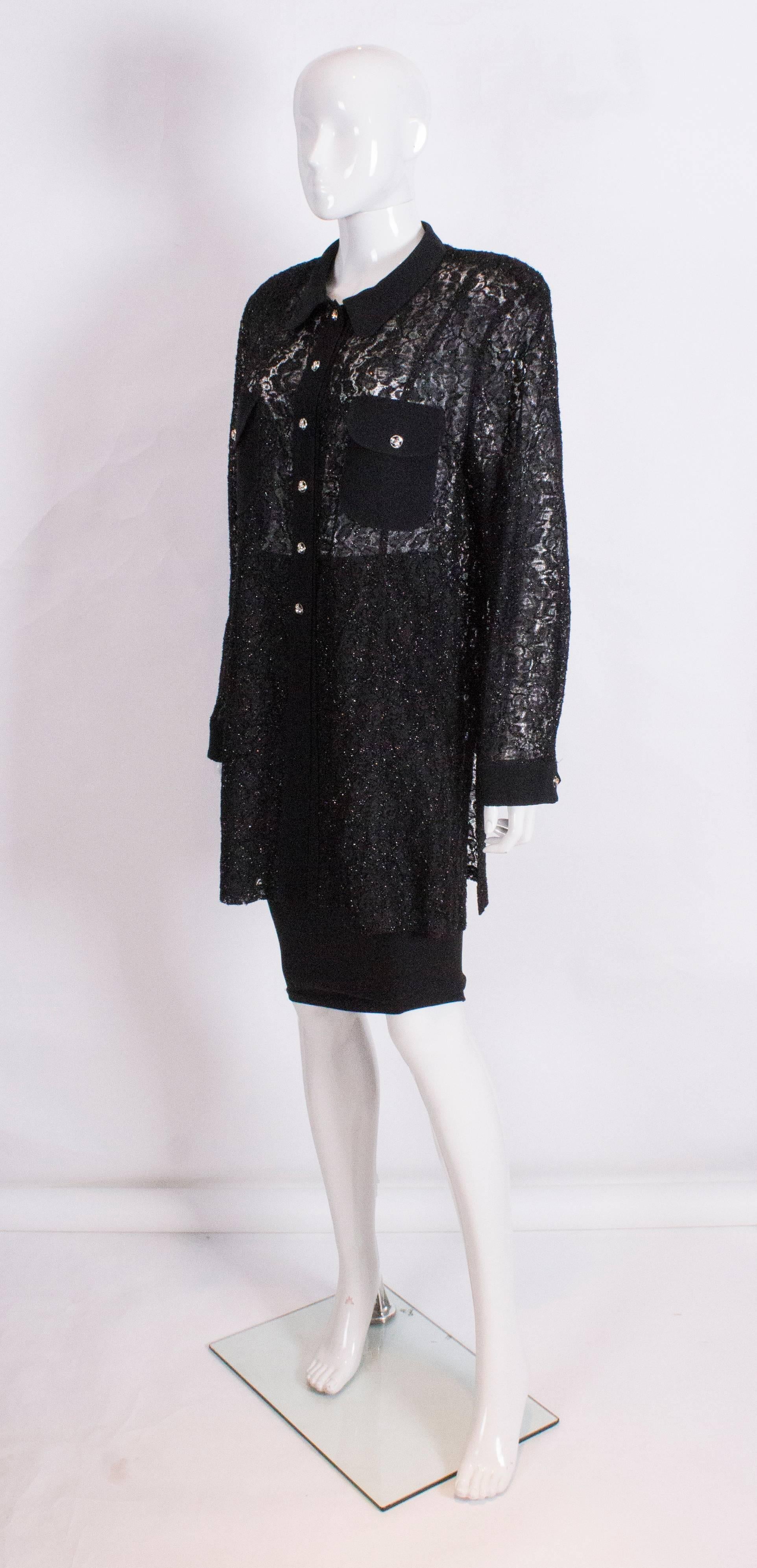 A  chic vintage black evening shirt/jacket by British designer Hardy Amies. The shirt has a black   collar, 2 breast pockets, and a 6 button front opening. The fabric is a black sparkly lace. The shirt has 9 1/2'' slits at either side, and wonderful