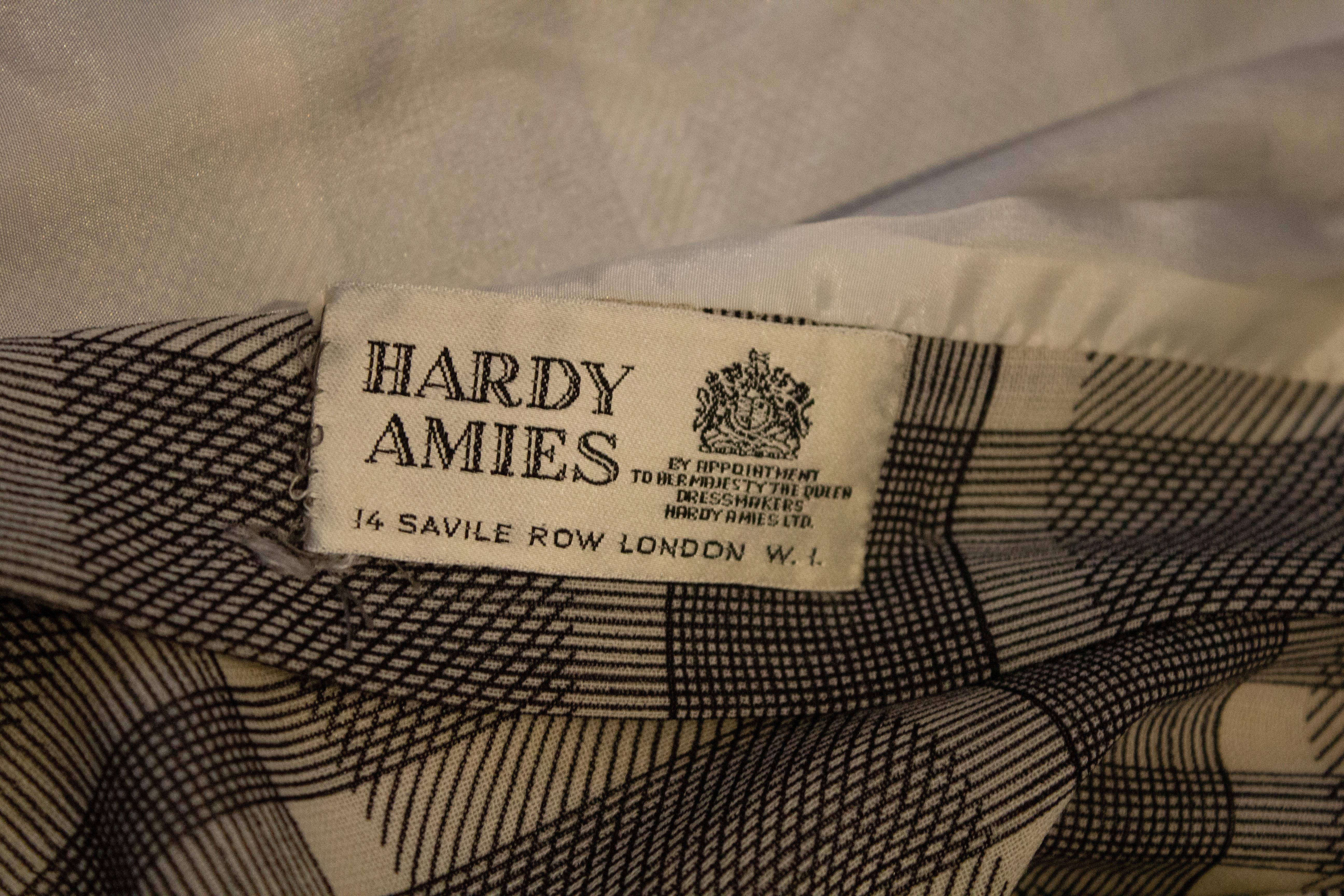A chic vintage Hardy Amies day dress in a ivory and black check. The dress has a double frill collar, and elbow length sleaves. Measurements: Bust 39'', waist up to 34''  , length 44''