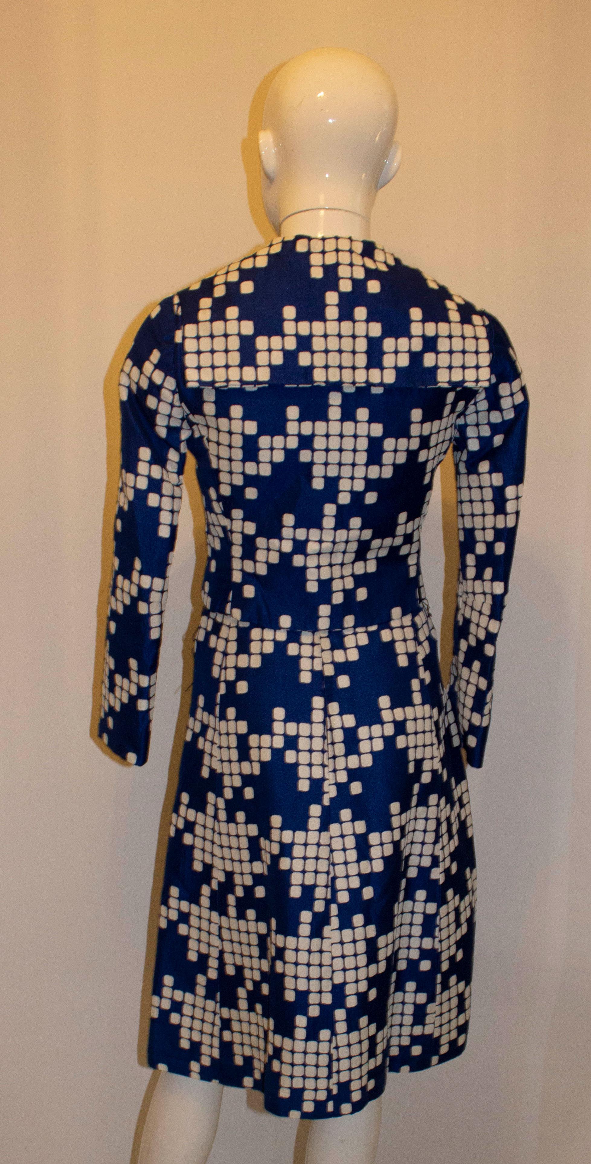 A stunning vintage dress and jacket by Hardy Amies. In a vibrant blue and white print , the dress has a round neckline , cap sleaves and a central back zip. It is lined, with belt hoops,  and has a matching belt with wonderful buckle.  The jackets