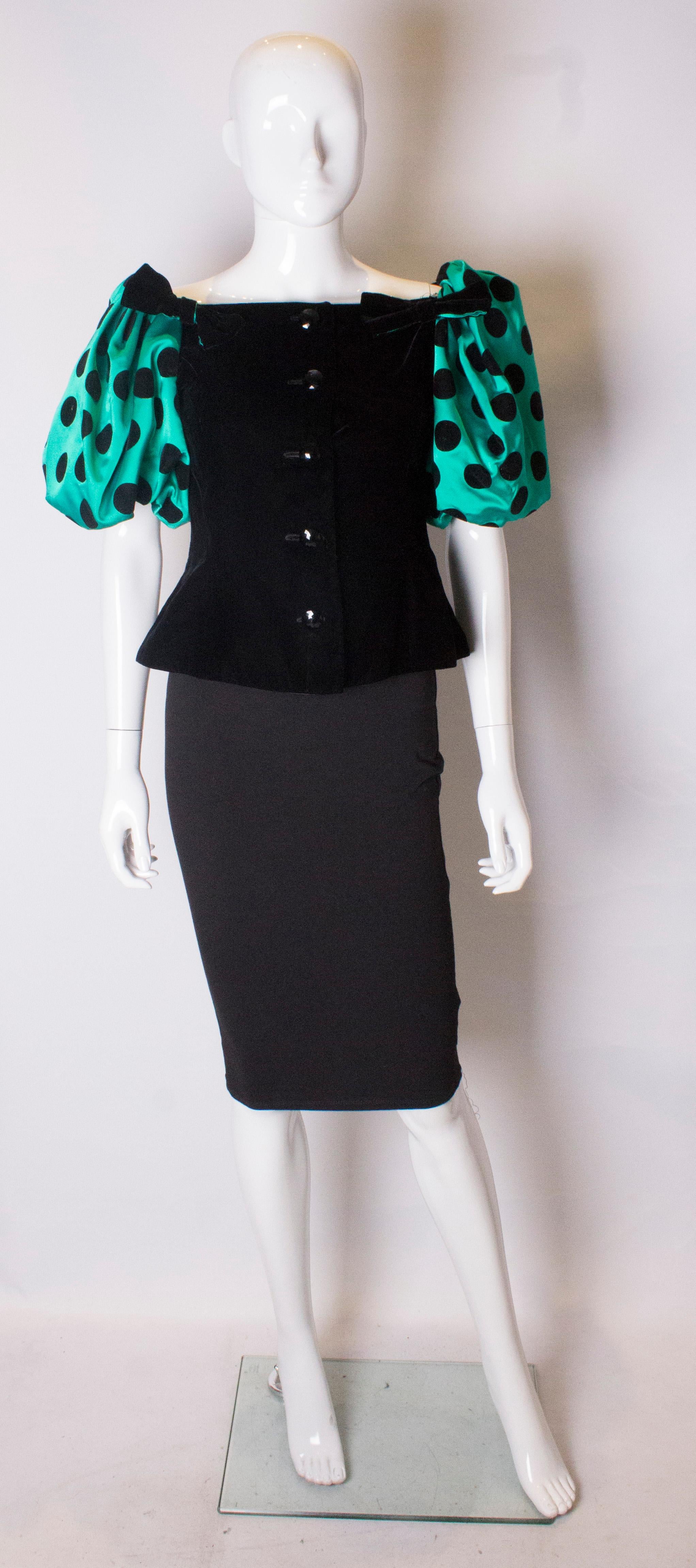 A great vintage top by Hardy Amies. The top has a black velvet central body and is fully lined, with button opening at the front and a vent at the back.The sleeves are puff green with black spots.
