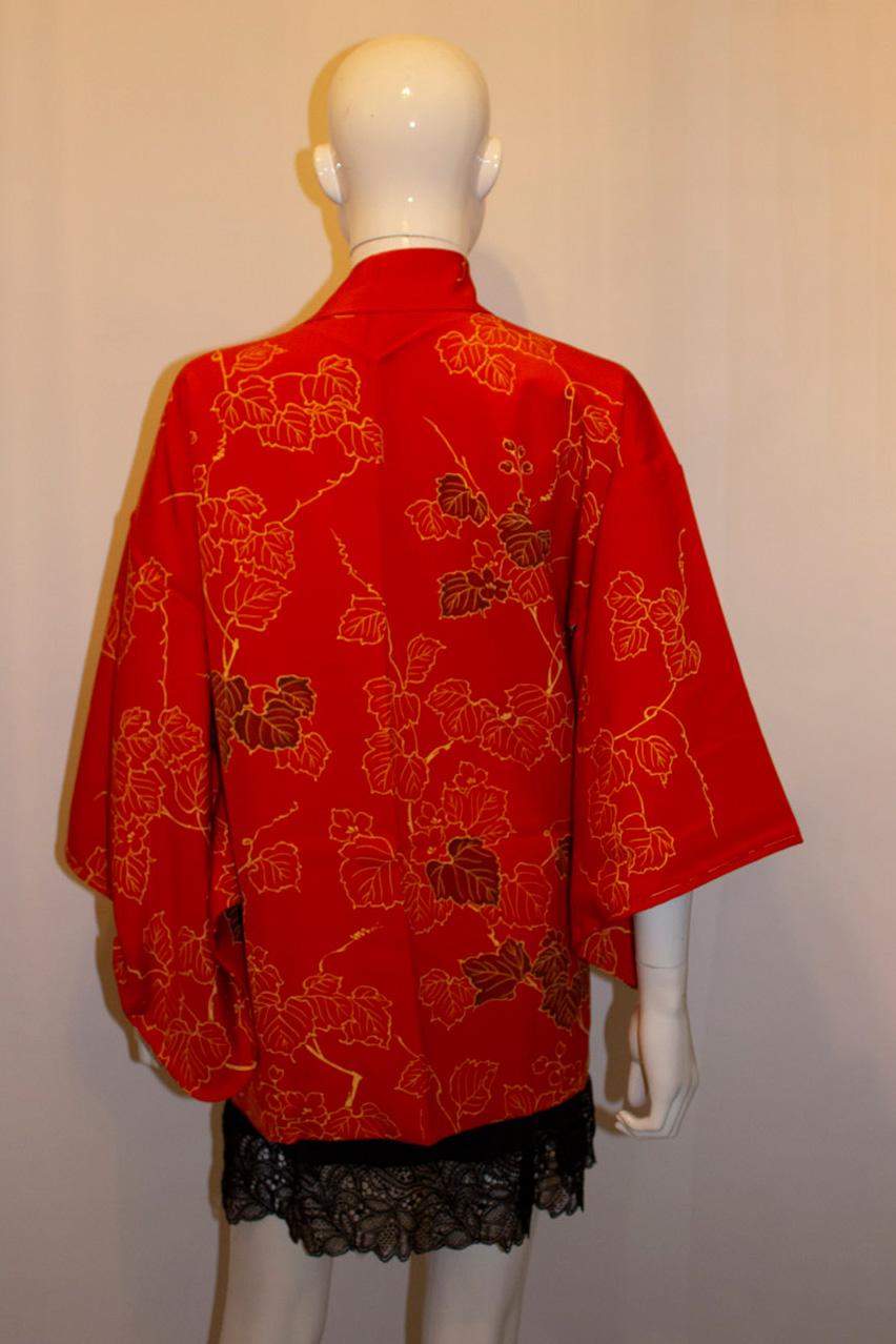 A headturning, short kimono/hari dating from the 1980s. The kimono has a lovely pattern of falling leaves, and has a pretty pink silk lining. 