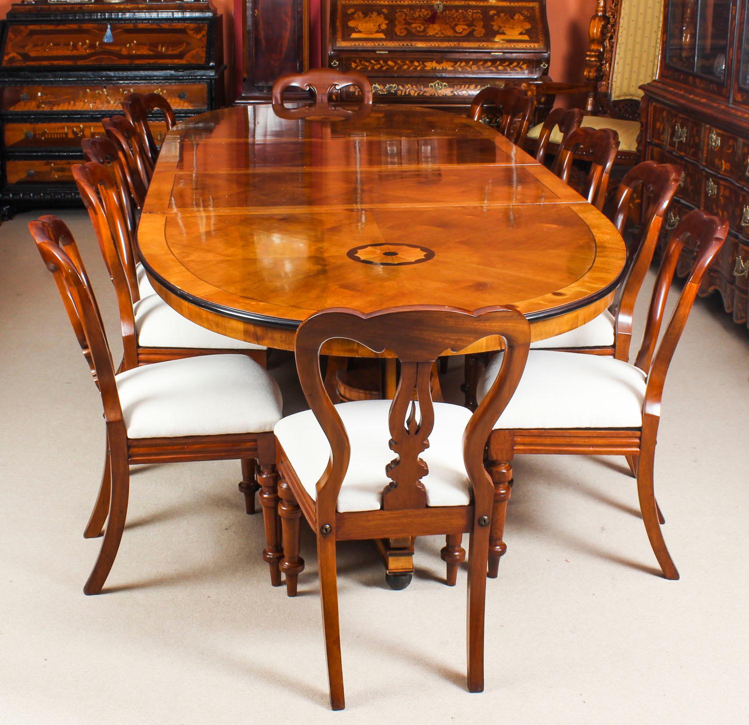 This is a fabulous high quality dining set comprising a satin birch twin pillar oval dining table purchased at great expense from Harrods, Knightsbridge, London in the 1980s and a set of twelve antique Victorian dining chairs.

The oval top with