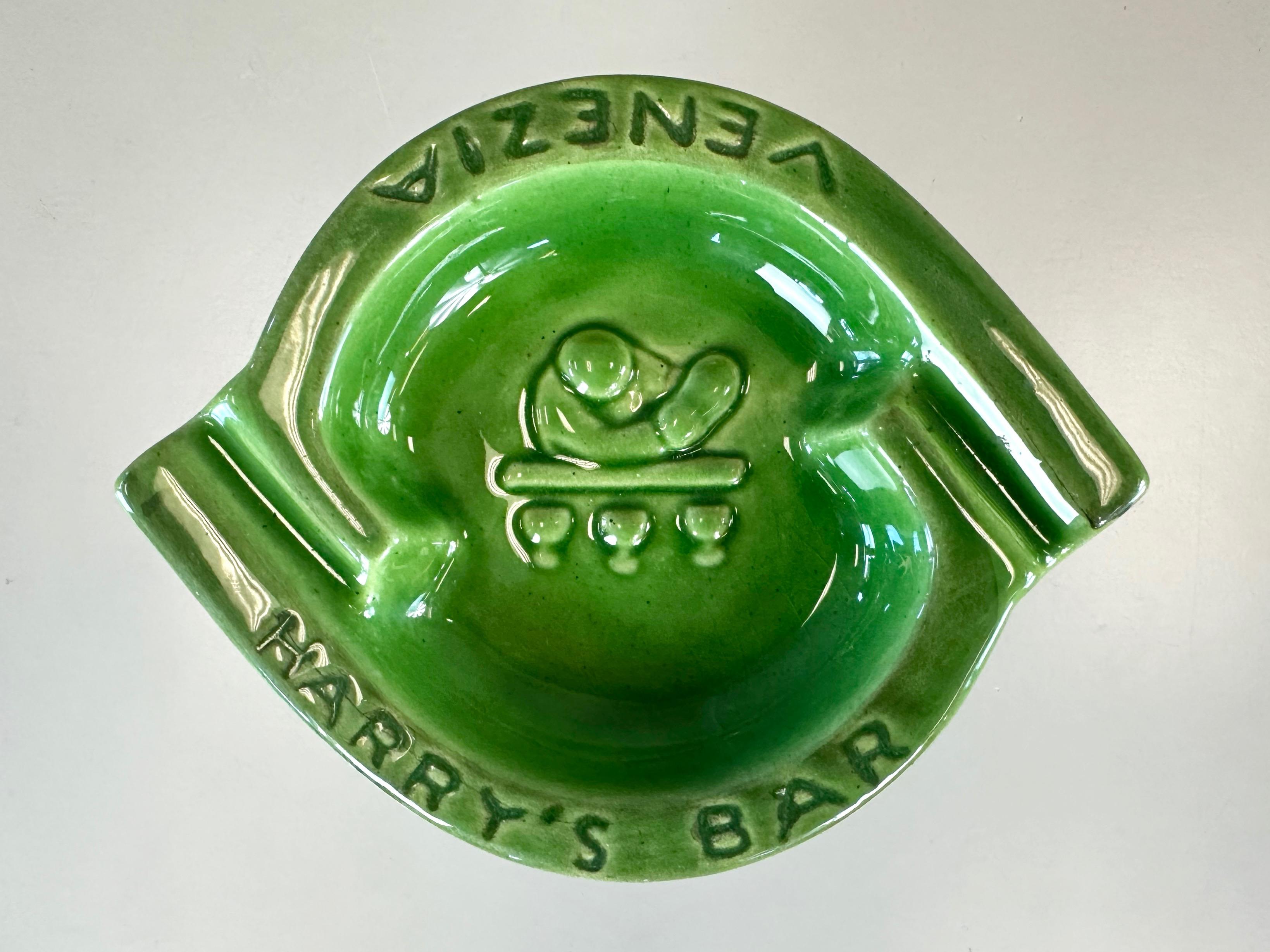 A 1960s green ceramic ashtray from the world renowned Harry’s Bar in Venice, Italy.

A very handsome and highly sought-after Italian expat, this dual-rest cigar or cigarette ashtray features the storied establishment's signature cocktail