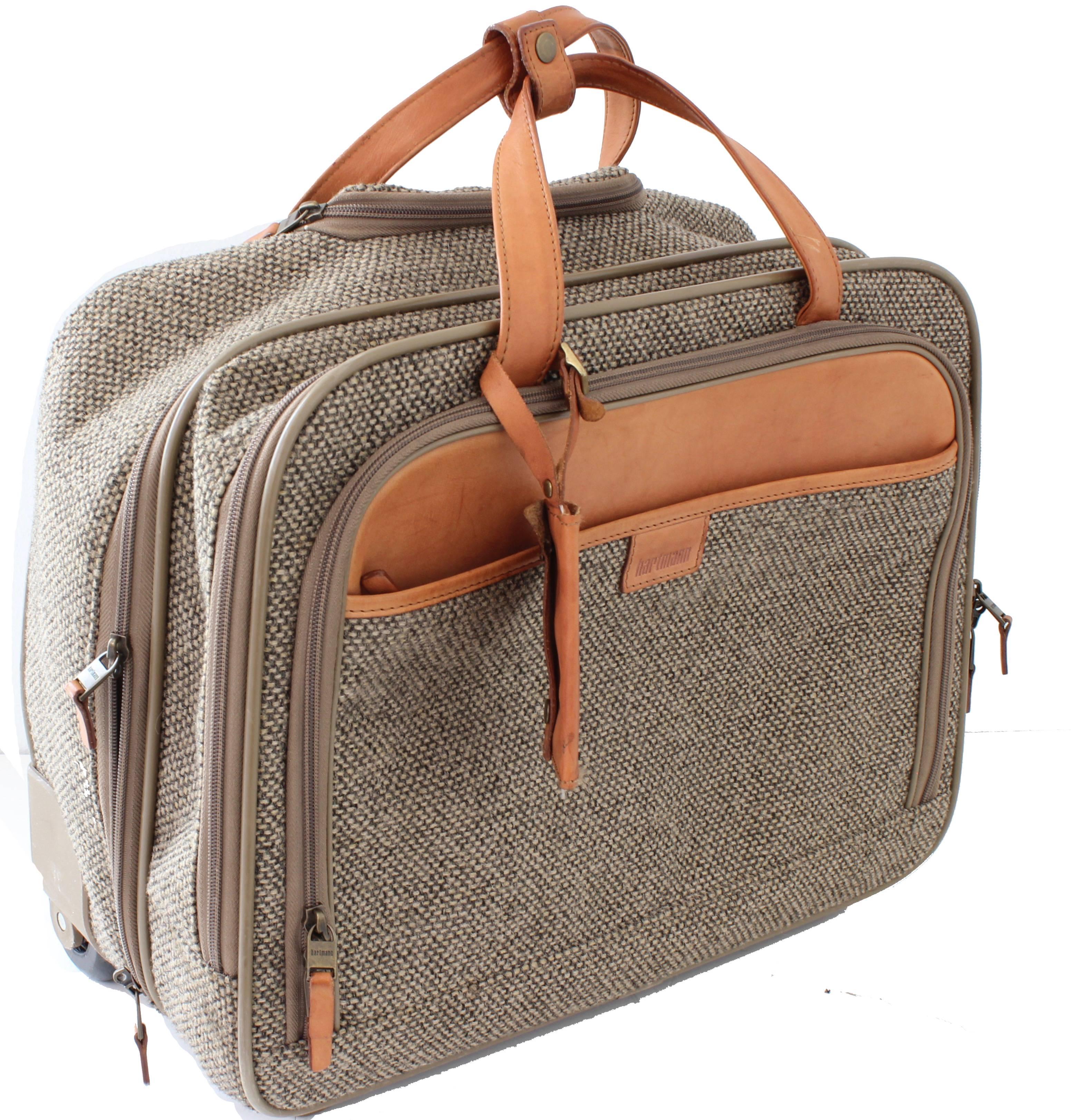 Ce sac à roulettes en tweed et en cuir a été fabriqué par Hartmann Luggage:: très probablement à la fin des années 1970.  Parfait pour les affaires ou les voyages:: il comporte une poignée roulante extensible avec insert en cuir:: deux compartiments