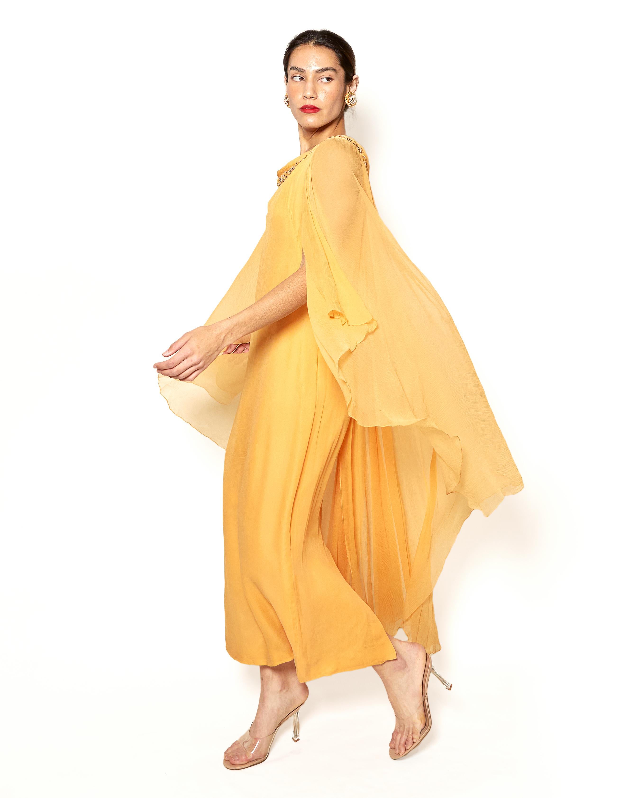 Indulge in royal elegance with the Hartnell 1960's Sherbert Dress. Designed by the renowned British designer, Norman Hartnell, known for his exquisite work for the royal family. Made of delicate silk, this flowing dress features an ornate neckline,
