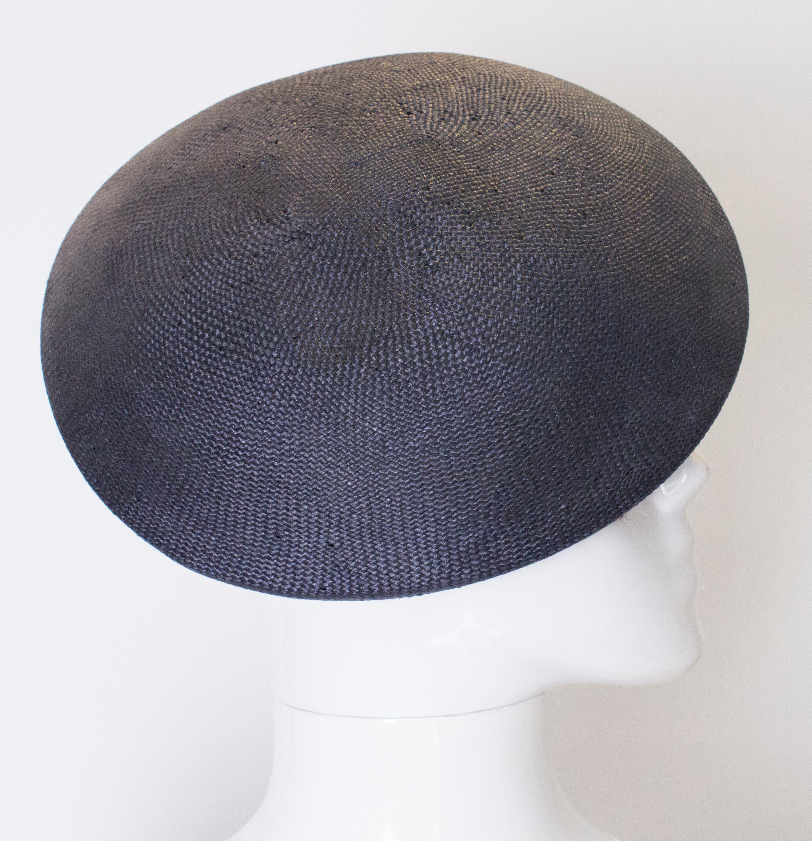 A very chic shaped hat by Viyella. The hat is in a dark blue viscose straw, in an interesting shape.
Inner circumference 23''.