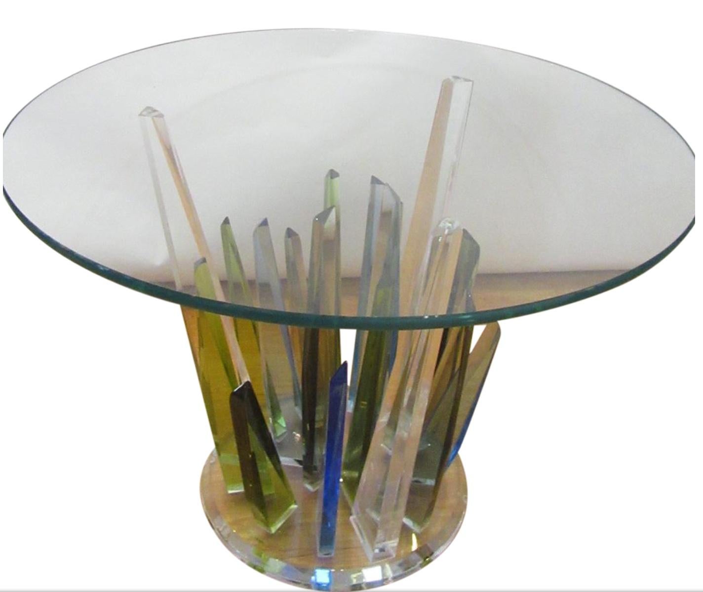 Stylish vintage Lucite coffee table with a round glass top accompanied underneath by a magnificent cool colored spectrum of blue and green Lucite sculpted to replicate stalagmites in their organic mineral form.