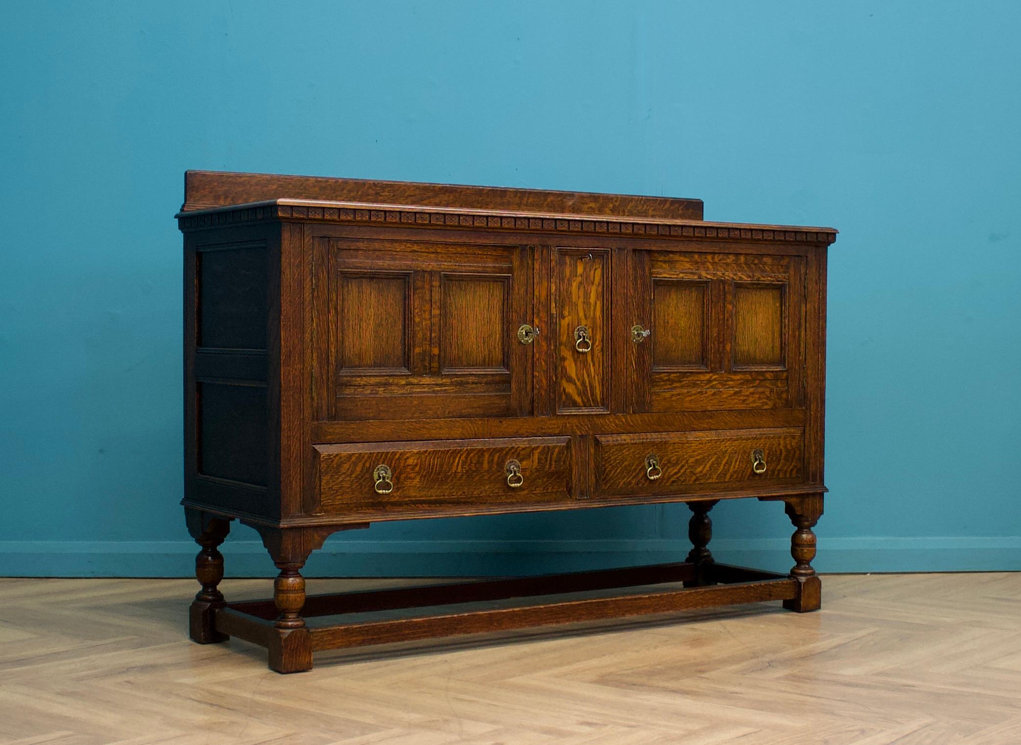 Un magnifique buffet en chêne de style Jacobean ou Tudor de Heals and Sons, datant des années 1920, conviendrait parfaitement à un intérieur de CIRCA.


Comprend deux armoires verrouillables et un tiroir à bouteilles verrouillable au milieu. Deux