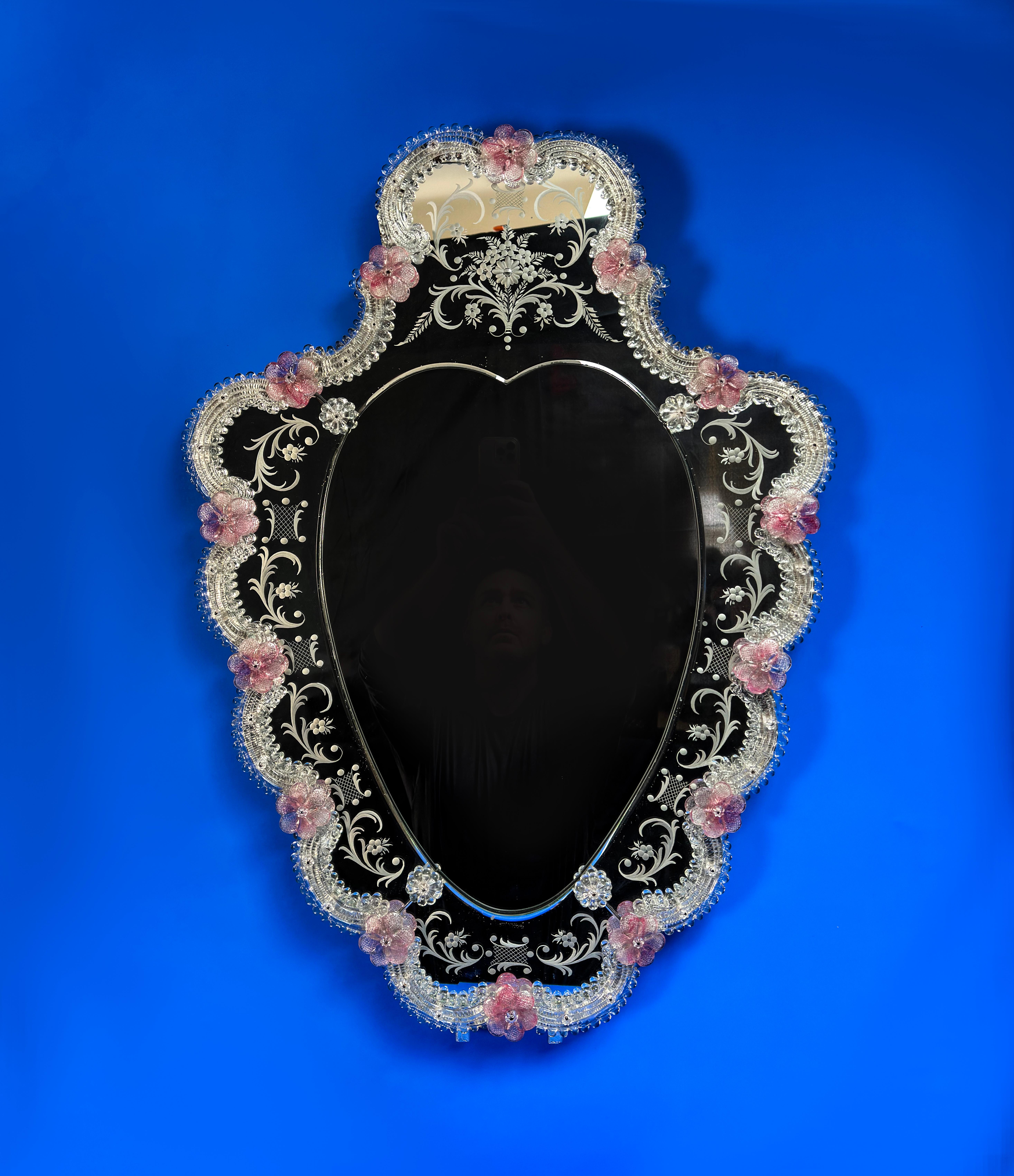 Magnifique miroir vénitien en forme de bouclier, fabriqué à Venise dans les années 1960.

Il présente une multitude de décorations et d'embellissements délicats. Le panneau extérieur en miroir est finement gravé d'un ensemble de volutes de style