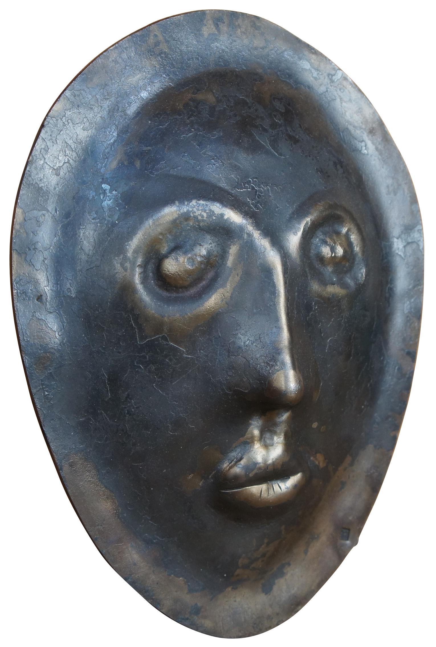 Masque funéraire en fer lourd, sculpture d'art moderne, avec un visage aplati et sans expression.  Estampillé TM.