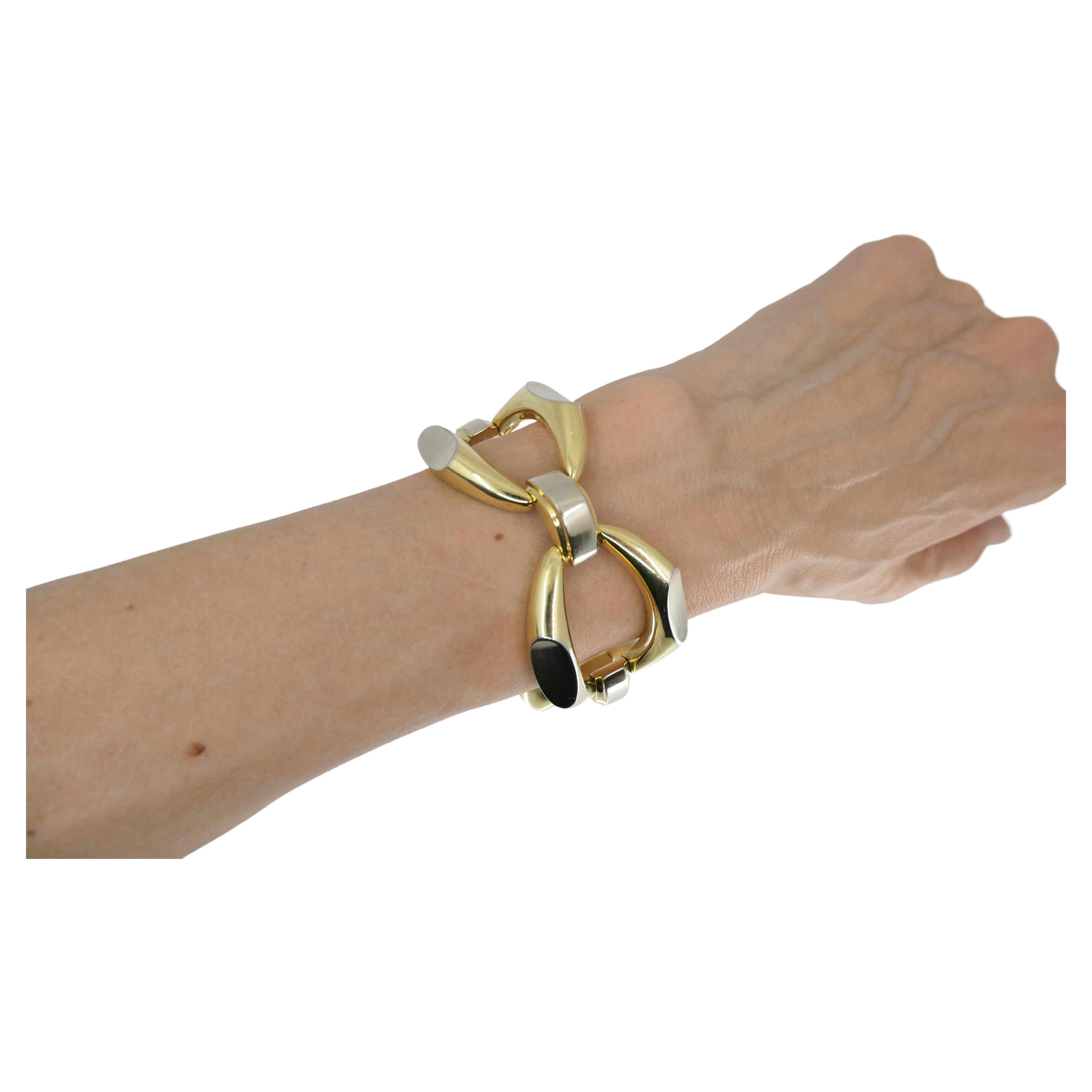 An impressive vintage heavy link bracelet made of 18k yellow and white gold. The bracelet comprises four larger convex oval links, connected by three smaller arched links. Each larger link are yellow gold with two white gold cuts on the sides. The