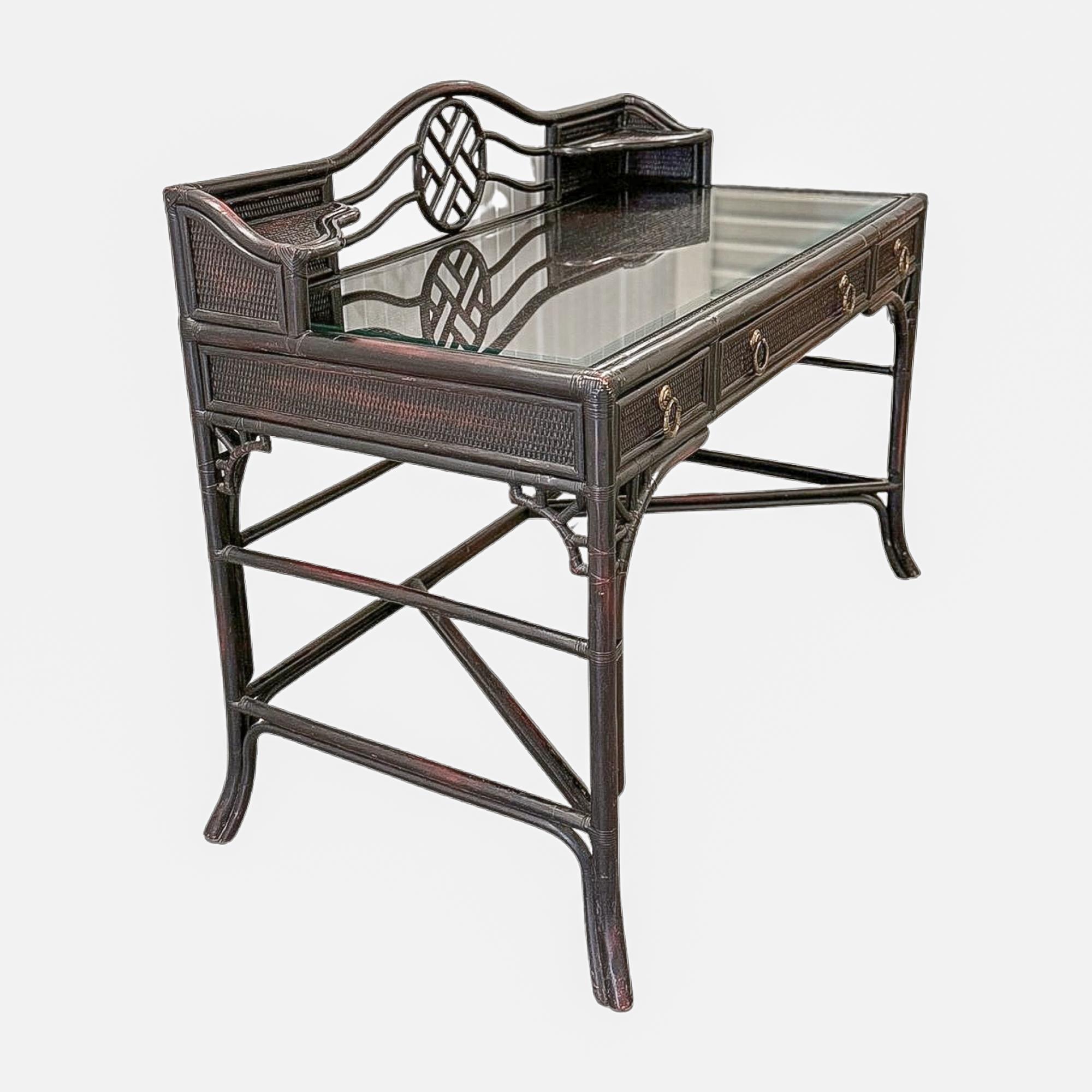 Striking in ebonized rattan, this vintage Hekman desk pairs sculptural form with timeless functionality. The stained black finish reveals warm undertones, allowing the natural cane texture to shine through while adding depth and richness. A fitted
