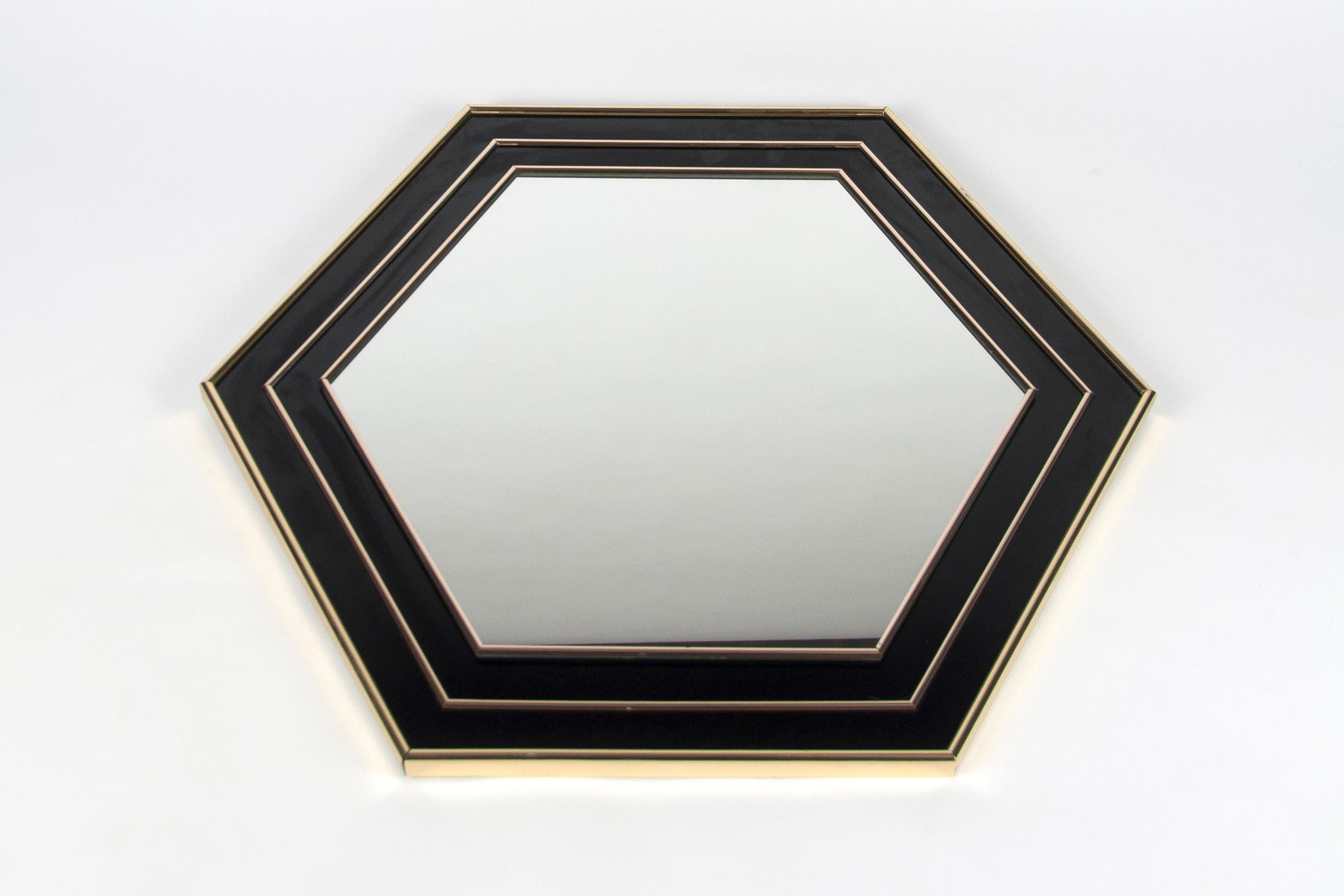 Superbe miroir hexagonal vintage en laque noire et laiton, attribué à Jean Claude Mahey. Très bonne qualité de fabrication, finitions de qualité.