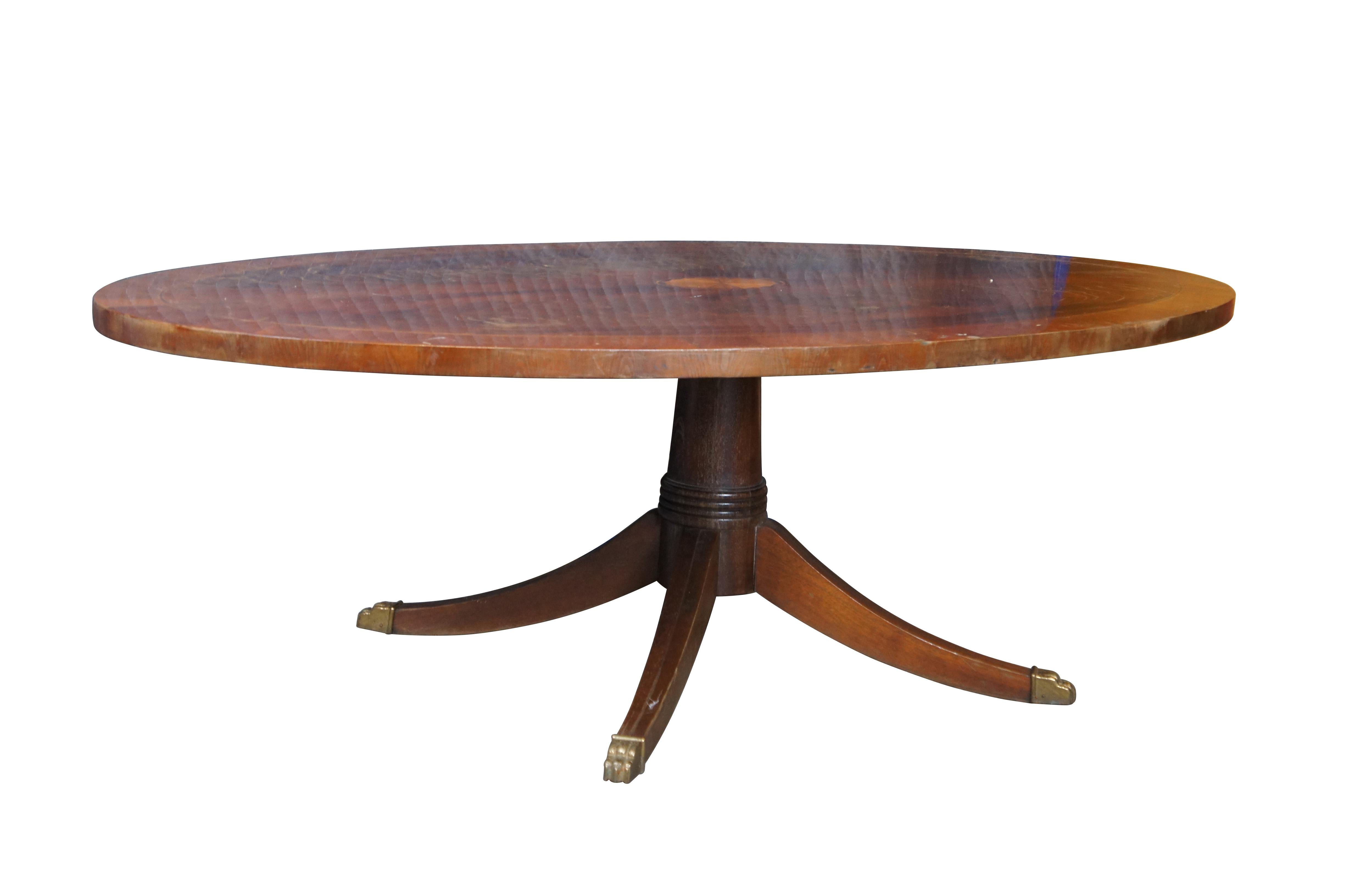 Vintage Hekman Furniture ovaler Couchtisch oder Cocktailtisch im englischen georgianischen Stil mit Platte aus Mahagoni und Intarsien aus Satinholz auf einem Sockel mit vier geformten, gespreizten Beinen, die mit Klauenfüßen aus Messing gekrönt
