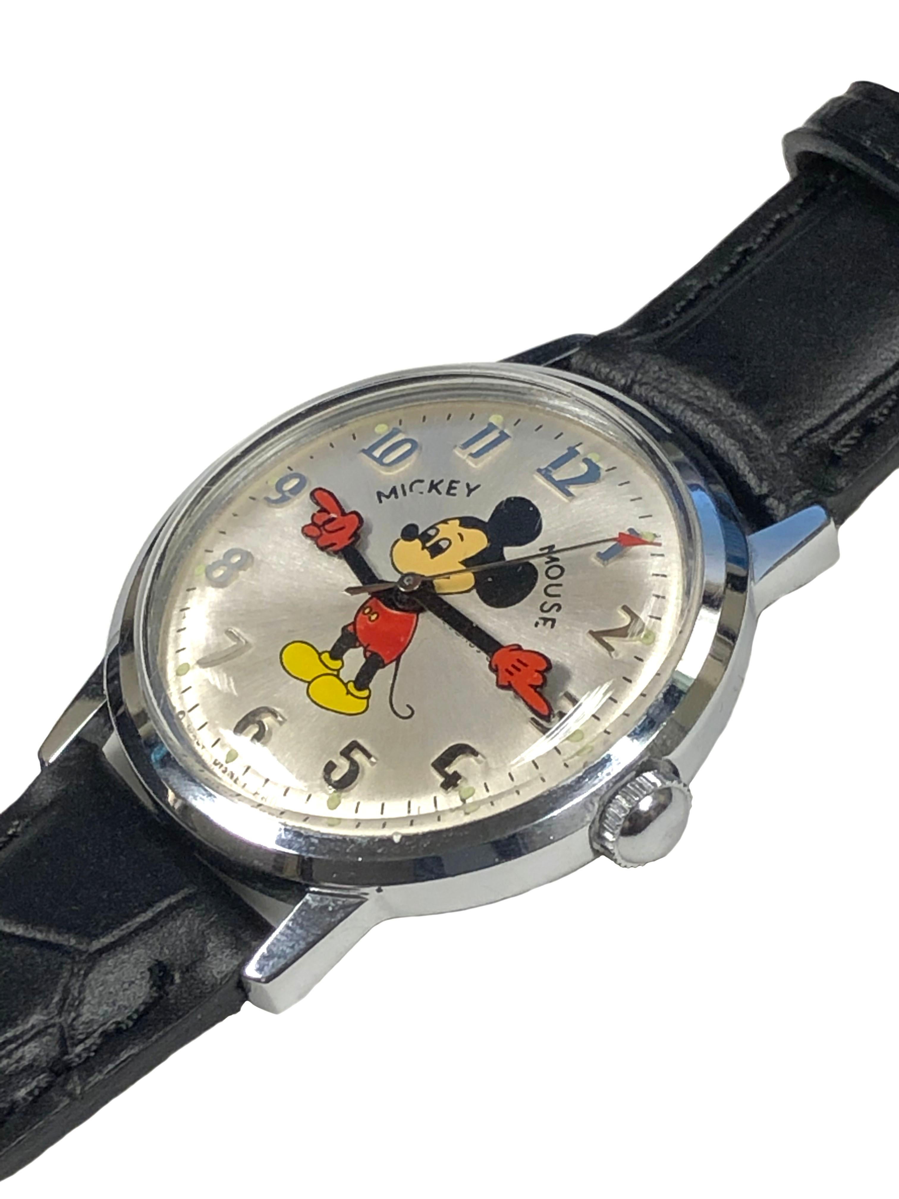 Circa 1970s Mickey Mouse Wrist Watch by Helbros, 34 M.M. Stainless Steel 2 Piece Water resistant case, 17 Jewel, Mechanical Manual wind movement. Bright Silver Dial with Raised Arabic Numeral Markers, sweep seconds Hand and animated Mickey Hands.
