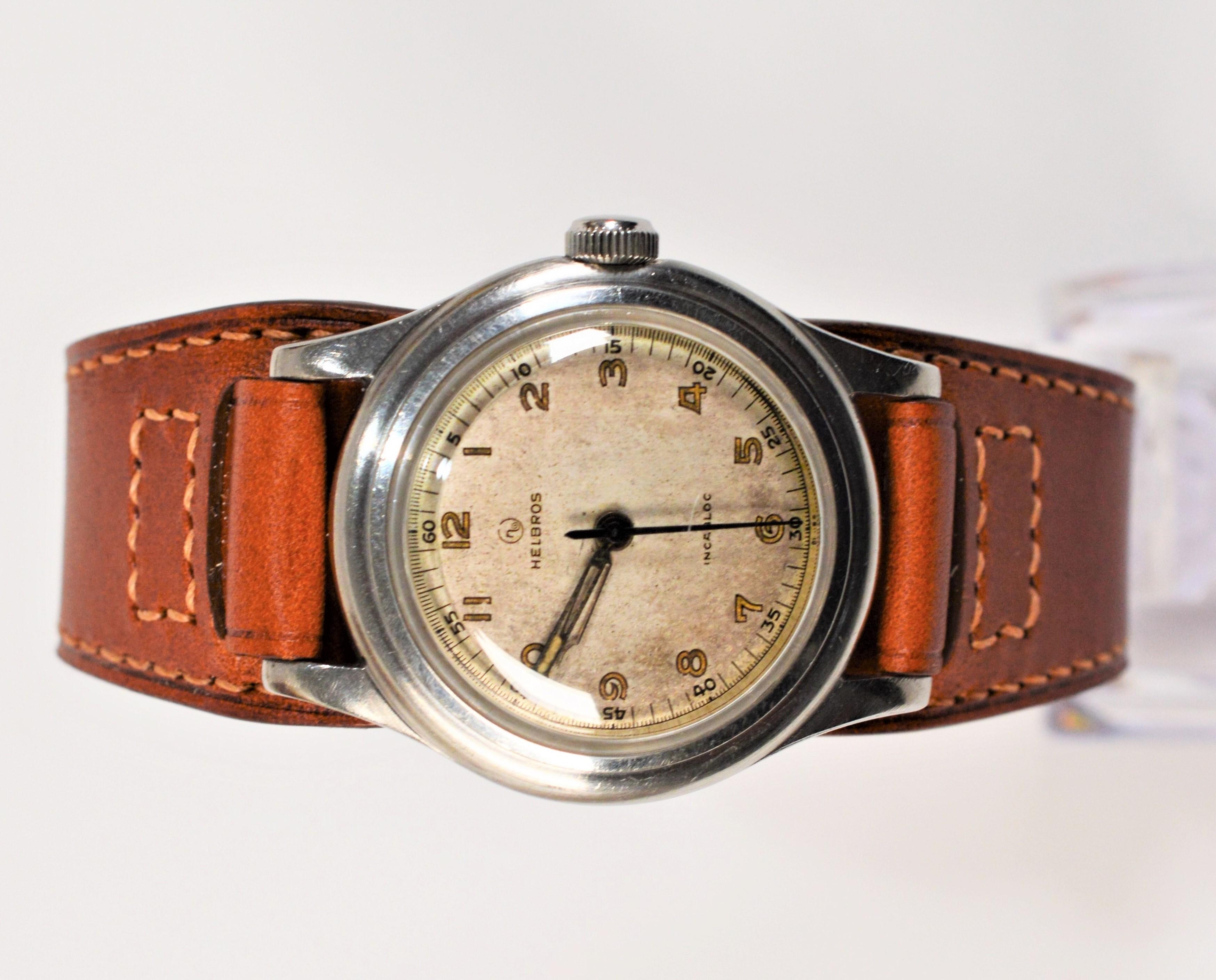Diese Helbros-Armbanduhr mit 33-mm-Stahlgehäuse erinnert an die Ära des Zweiten Weltkriegs und vermittelt ein echtes Vintage-Gefühl. Handaufzug mit einem siebensteinigen Uhrwerk  Die Uhr befindet sich im Originalzustand und hat viel Charakter. Ein