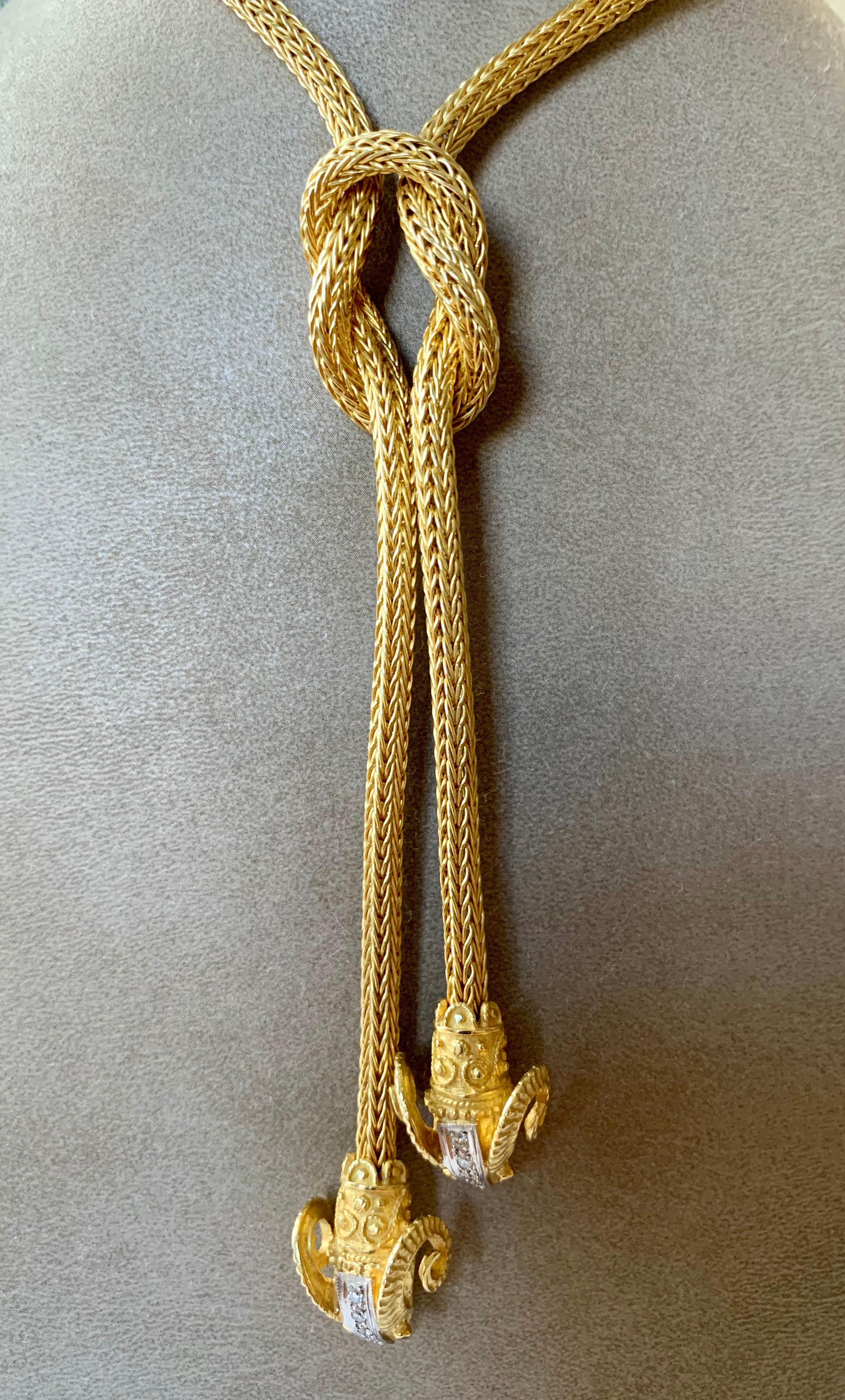 Lalaounis 18 K  yellow Gold Lavalier Style Braided Rope Necklace featuring two signature Ram's heads hanging from an oversize knot. The necklace measures approximately 49 cm length with another 13 cm from the top of the knot to the bottom of the