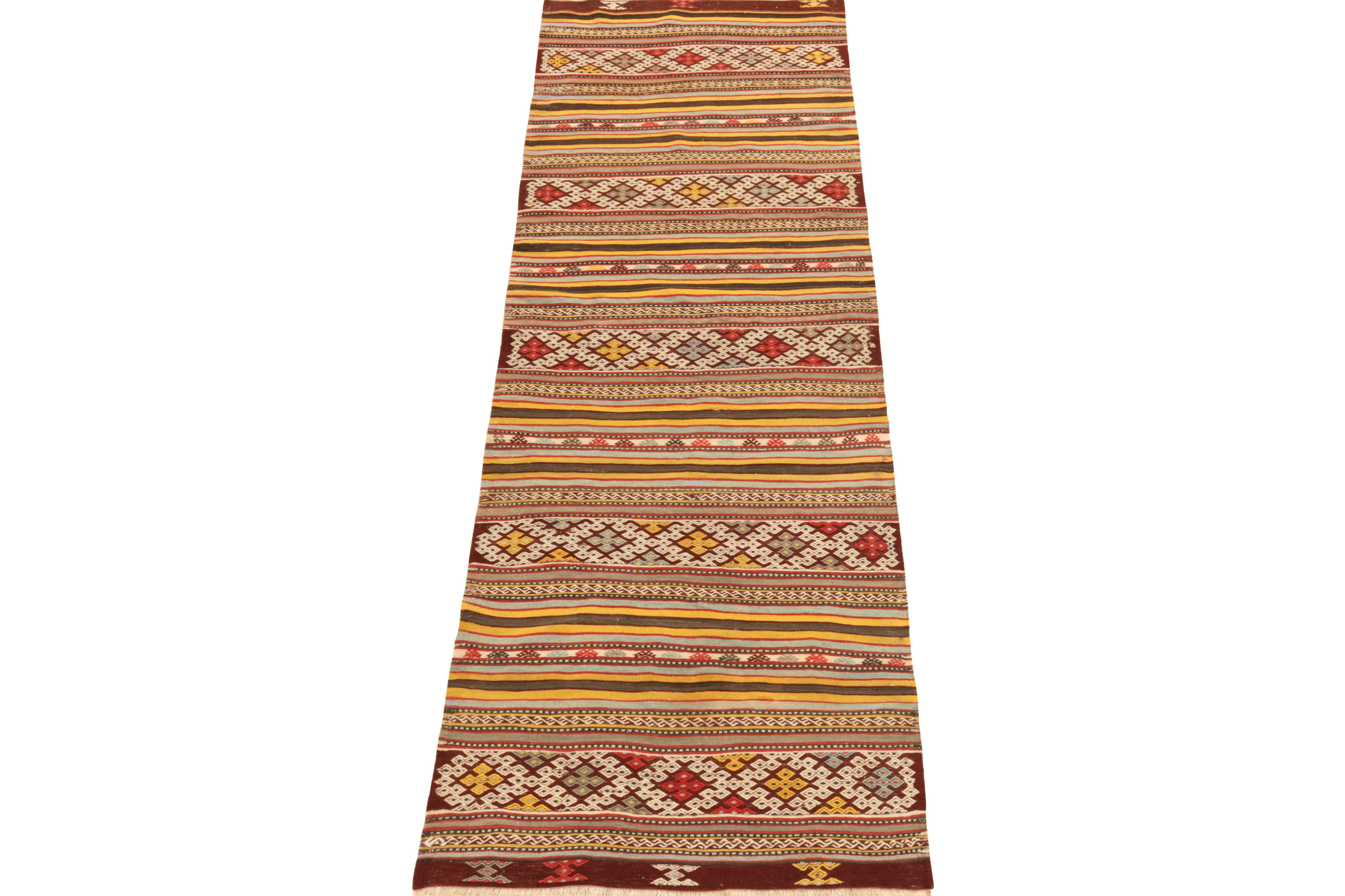 Handwoven in fine wool, a 3x9 Helvaci piece from our Kilim & Flatweave collection. Originating from Turkey circa 1950-1960, this vintage kilim runner reads striped variations & fine tribal motifs in lively yellow, red, white & grey-blue tones